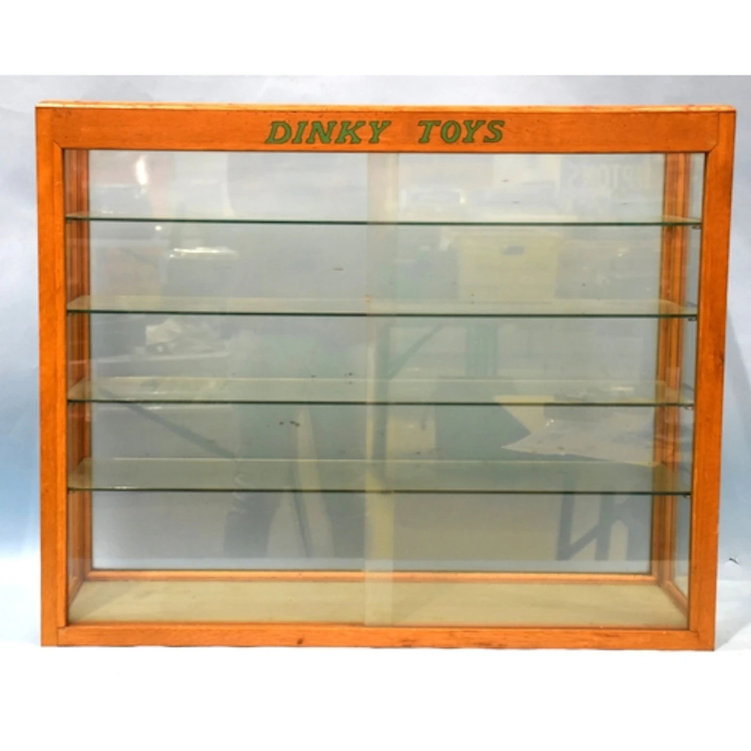 A Dinky Toys wood and glass counter display cabinet with two...