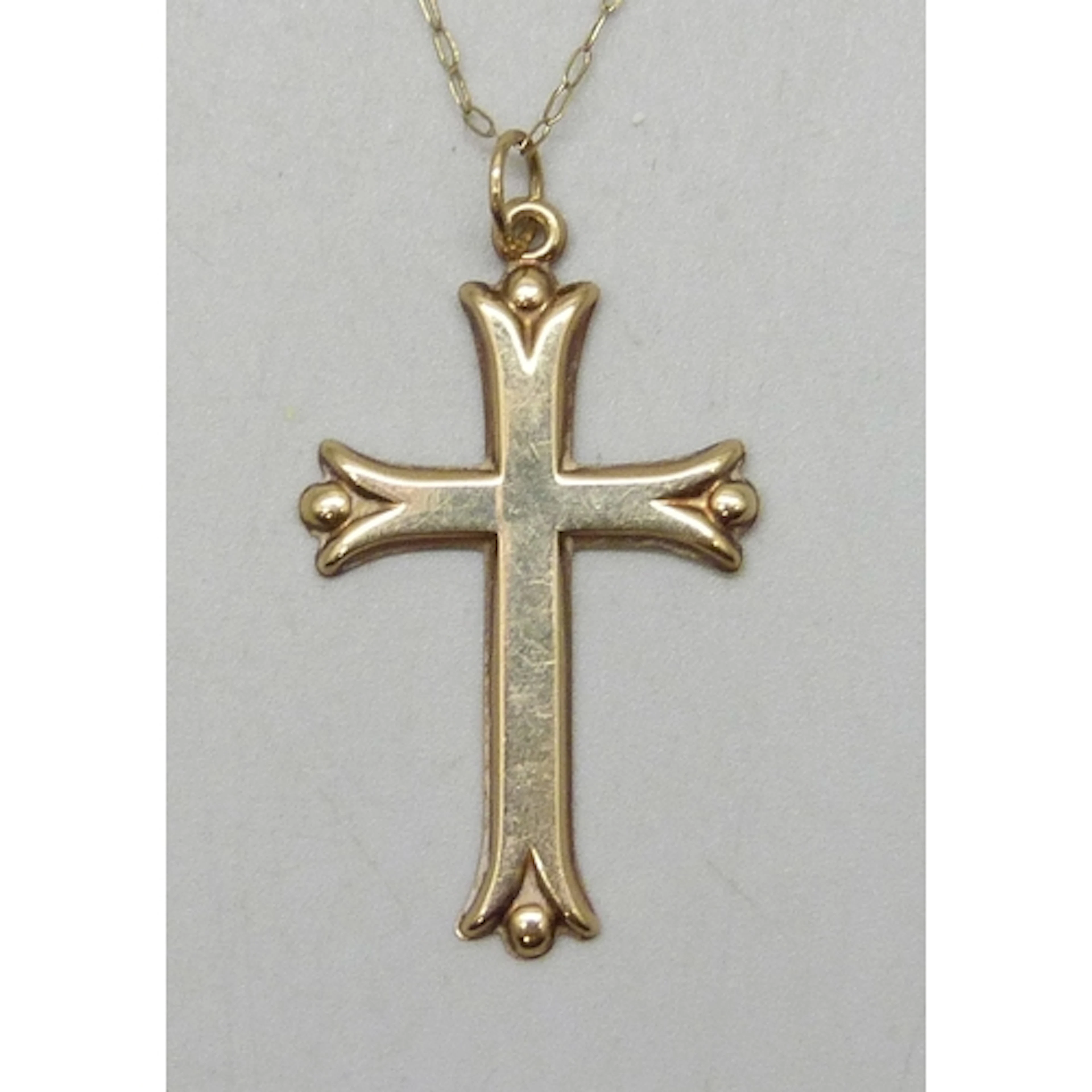 A yellow metal cross pendant, 3.4cm including bail, on a 9ct...