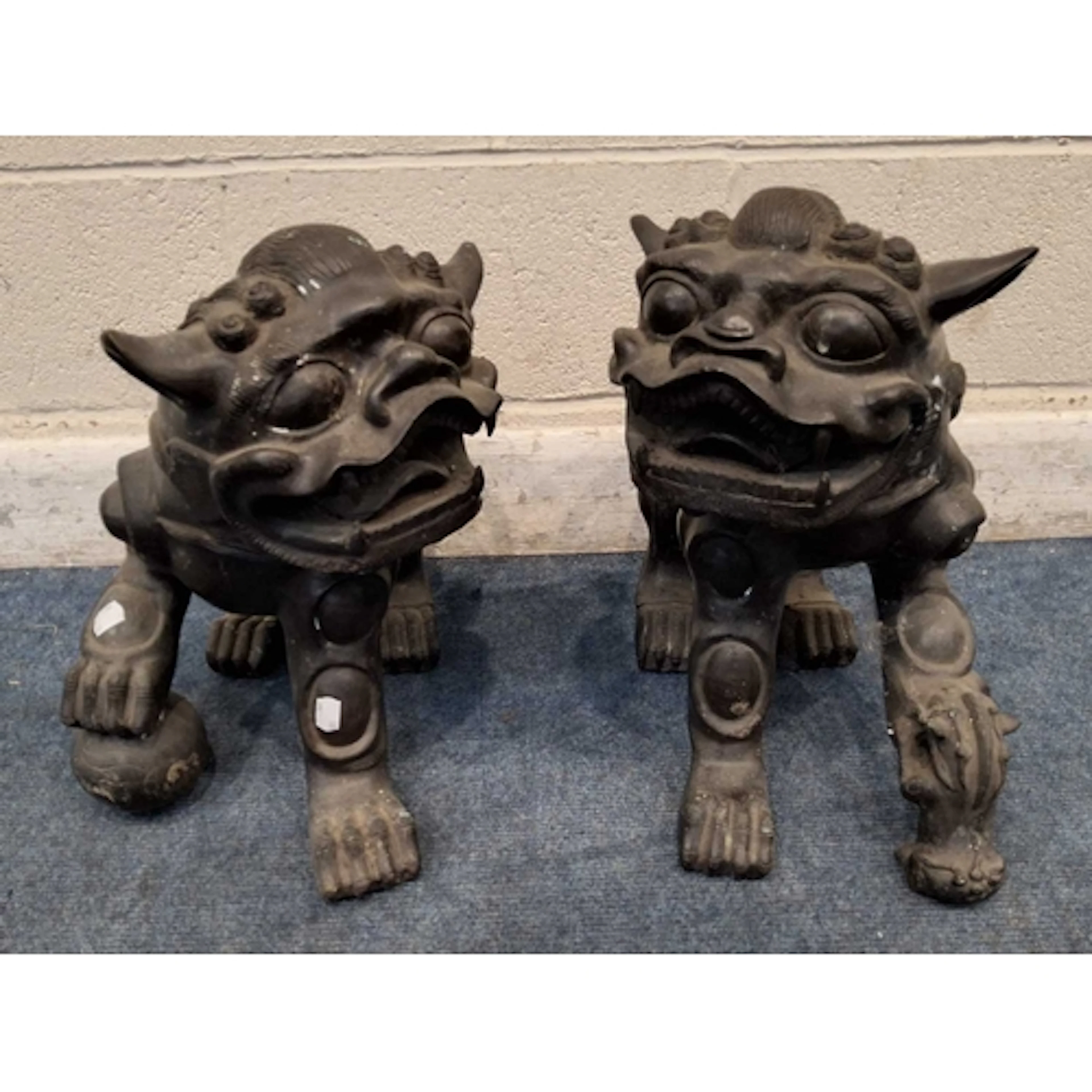 AN OPPOSING PAIR OF HOLLOW BRASS TEMPLE / FOO DOGS, one with...