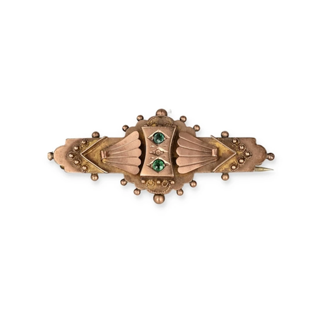 A VICTORIAN 9 CARAT GOLD BROOCH Set with two small emeralds....