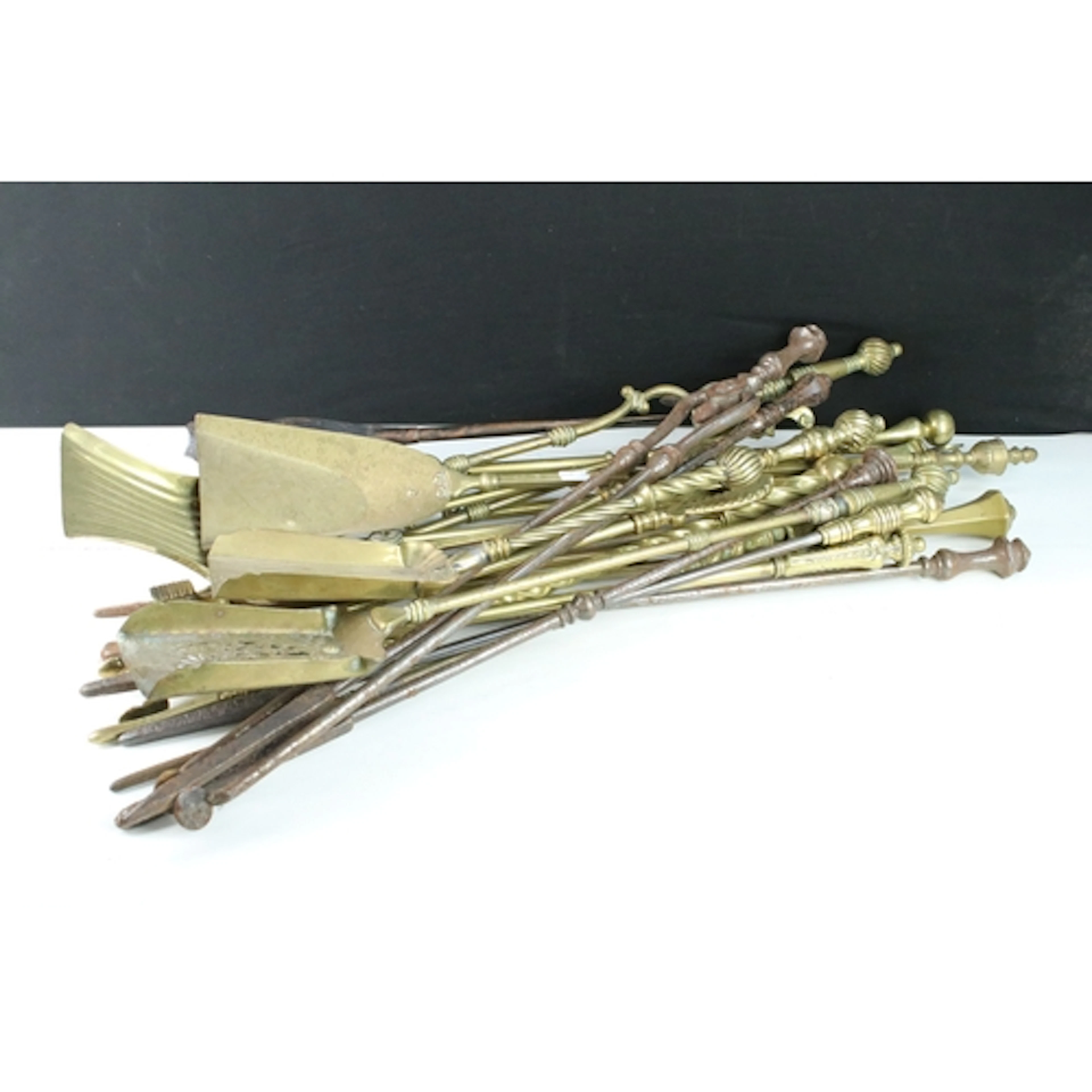 Collection of antique brass fire irons, to comprise pokers, ...