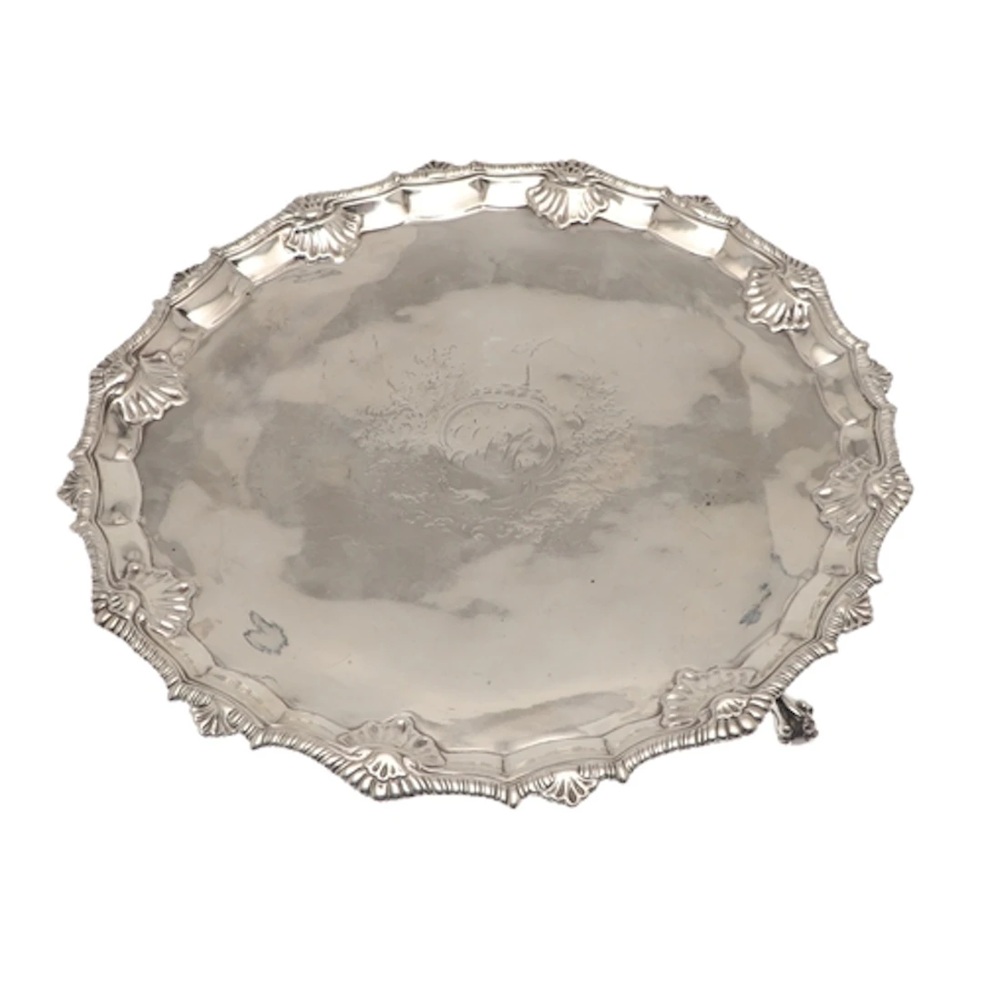 A GEORGE III SILVER SALVER. Of circular form, the border wit...