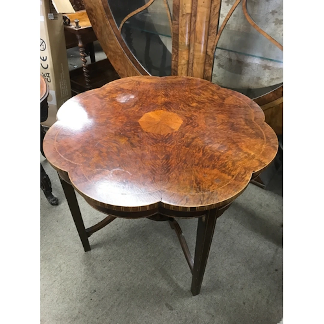 A burr walnut scalloped-edge coffee table with inlaid design...