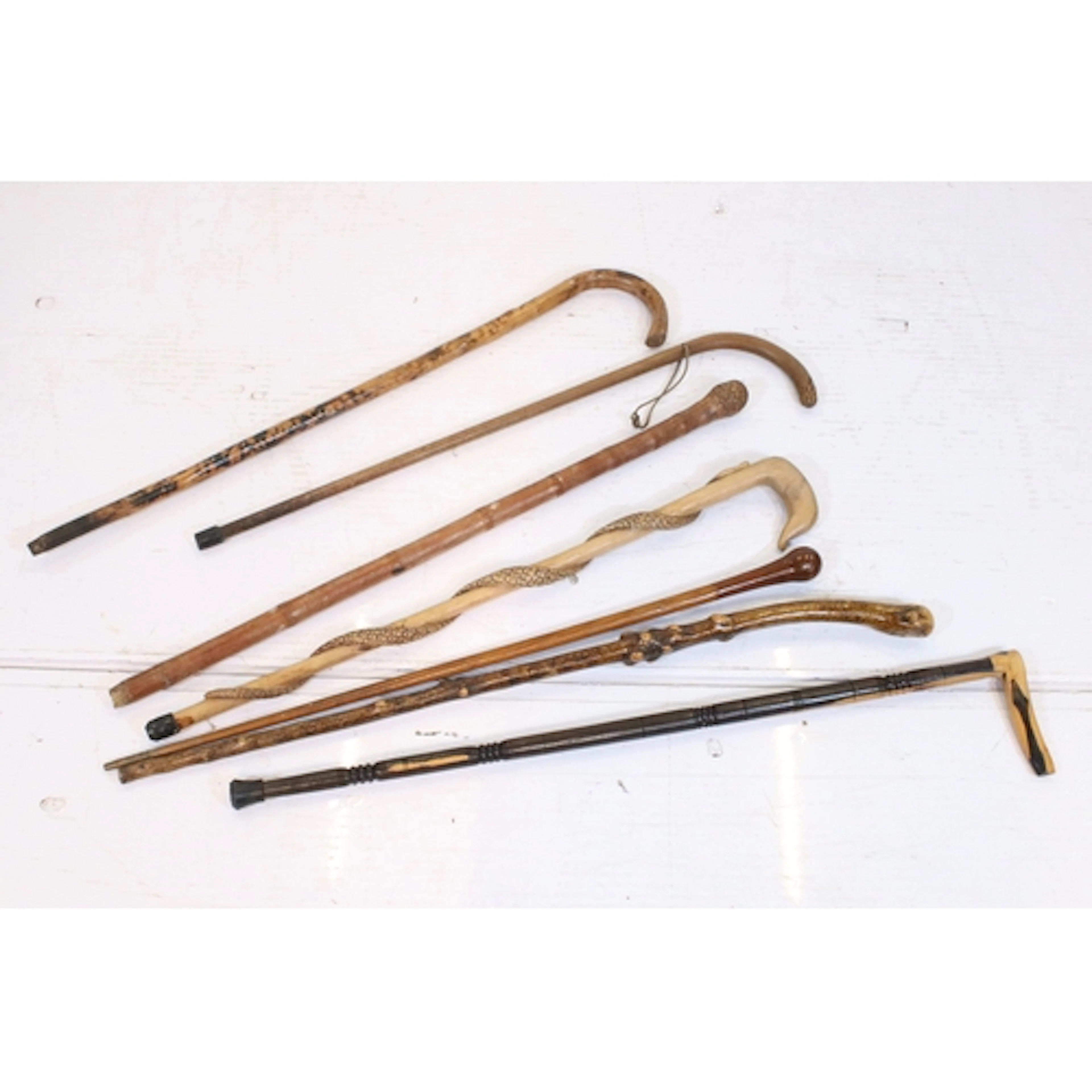 Group of seven walking sticks, to comprise carved examples, ...