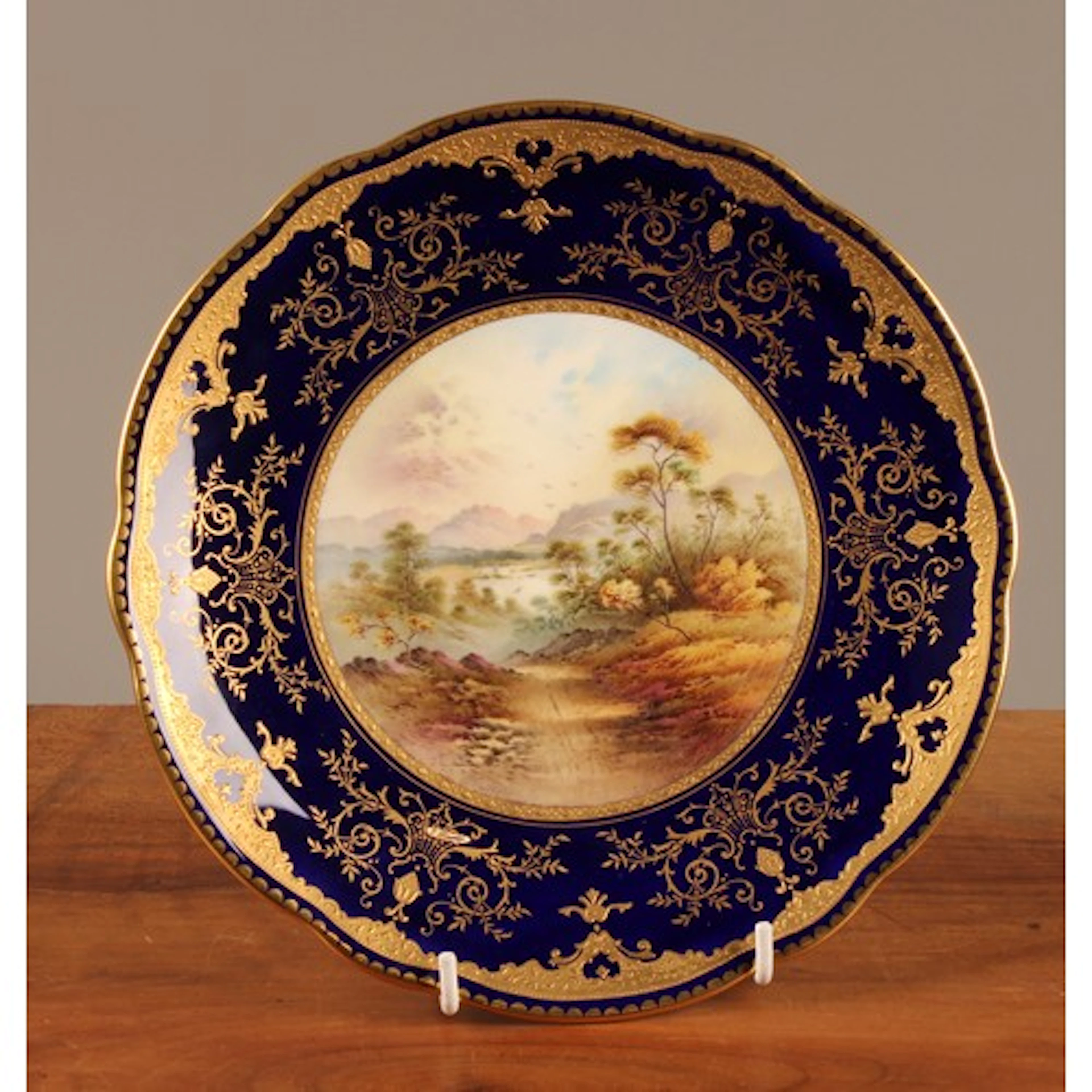 A Coalport named view shaped circular plate, painted by P. S...