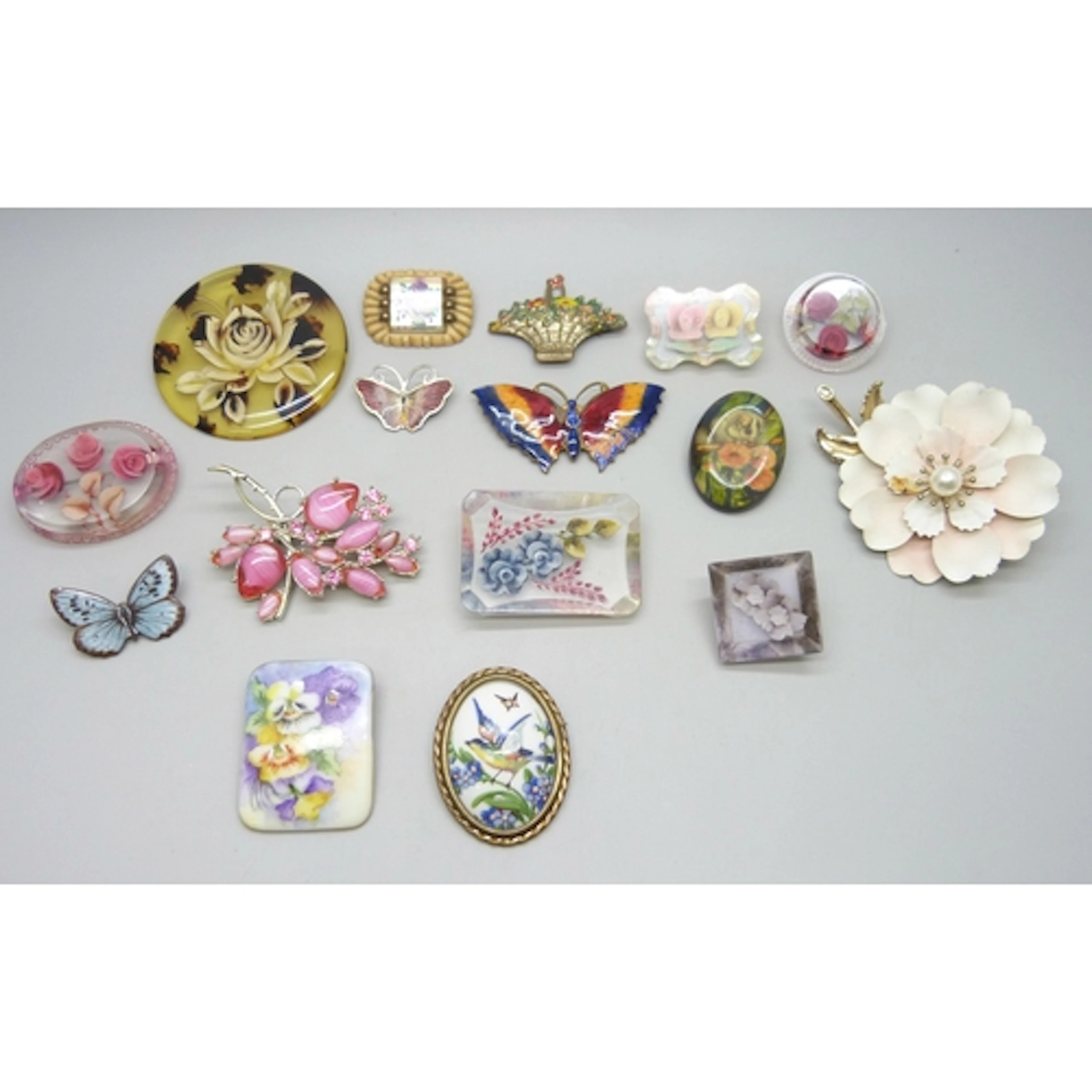 A collection of vintage brooches including resin floral exam...