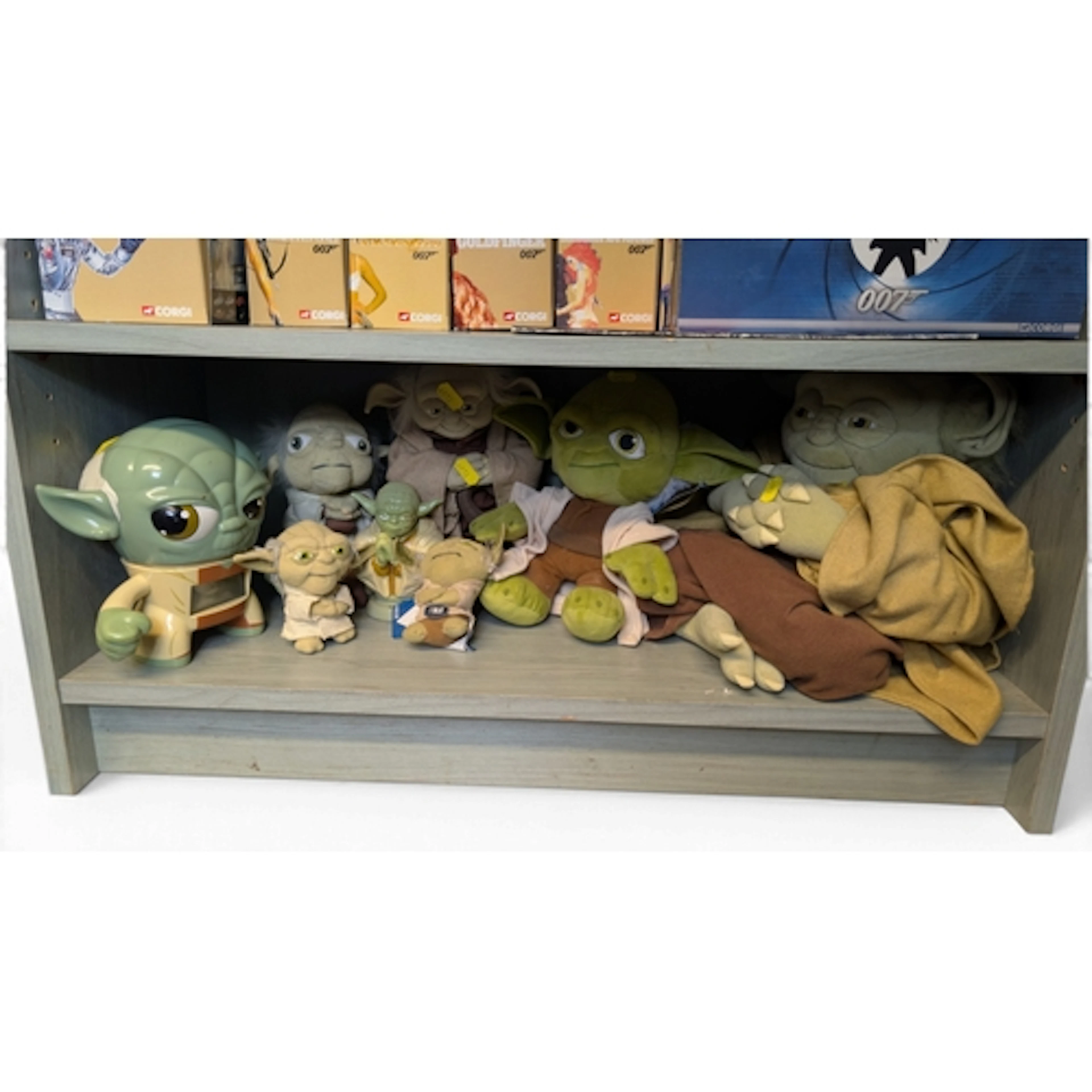 Shelf of Yoda figures inc. plushes, alarm clock and money ba...