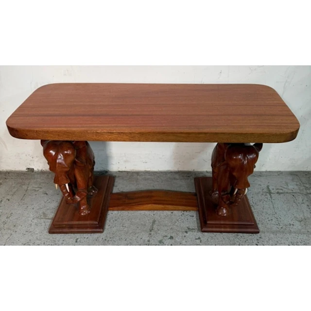 A wooden side table with carved elephamt supports and plinth...