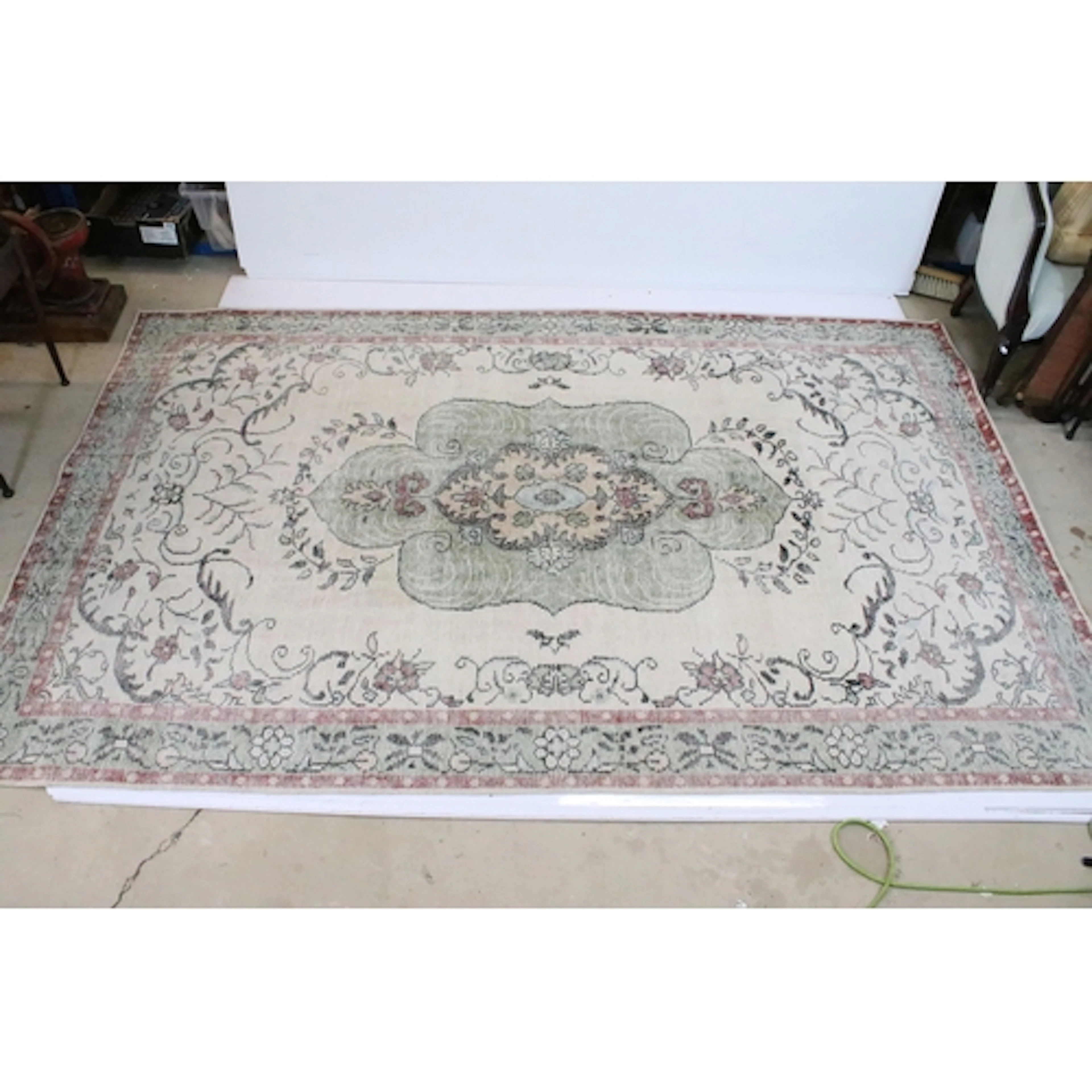 Oka cream ground rug, with central medallion within borders,...