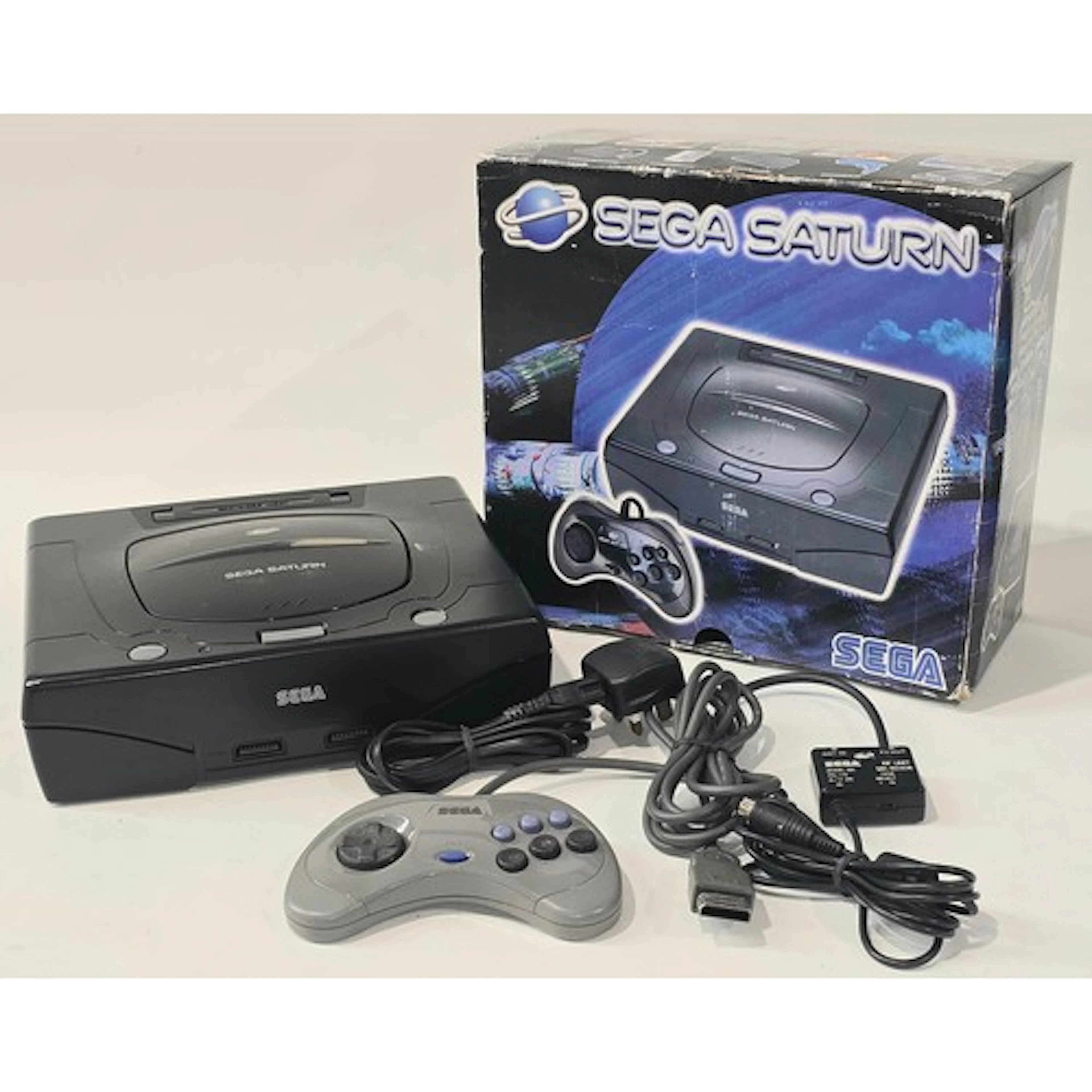 A vintage Sega Saturn games console appears c/w original box...