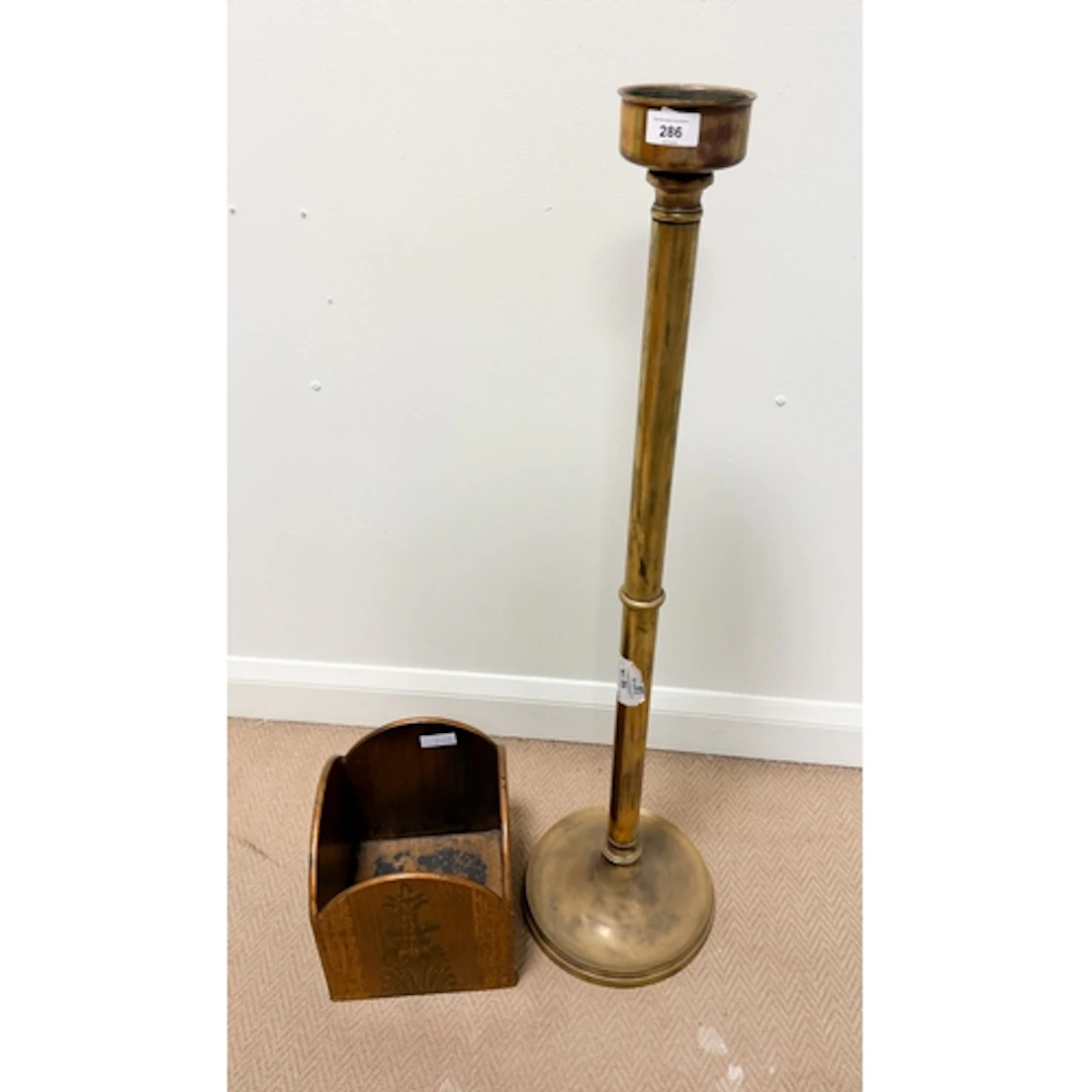 A floor standing brass ecclesiastical candle stick and a woo...