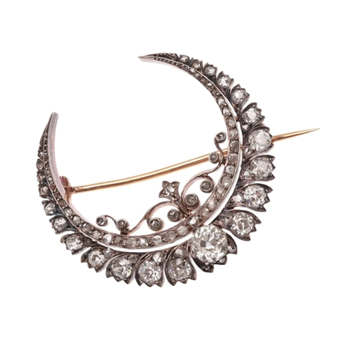 A VICTORIAN DIAMOND CRESCENT BROOCH. the crescent with scrol...