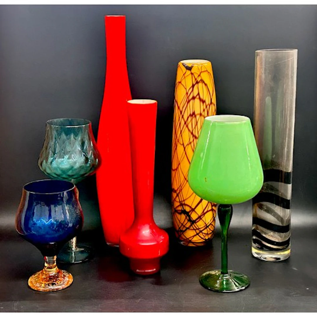 A collection of oversized coloured wine / brandy glasses, wi...