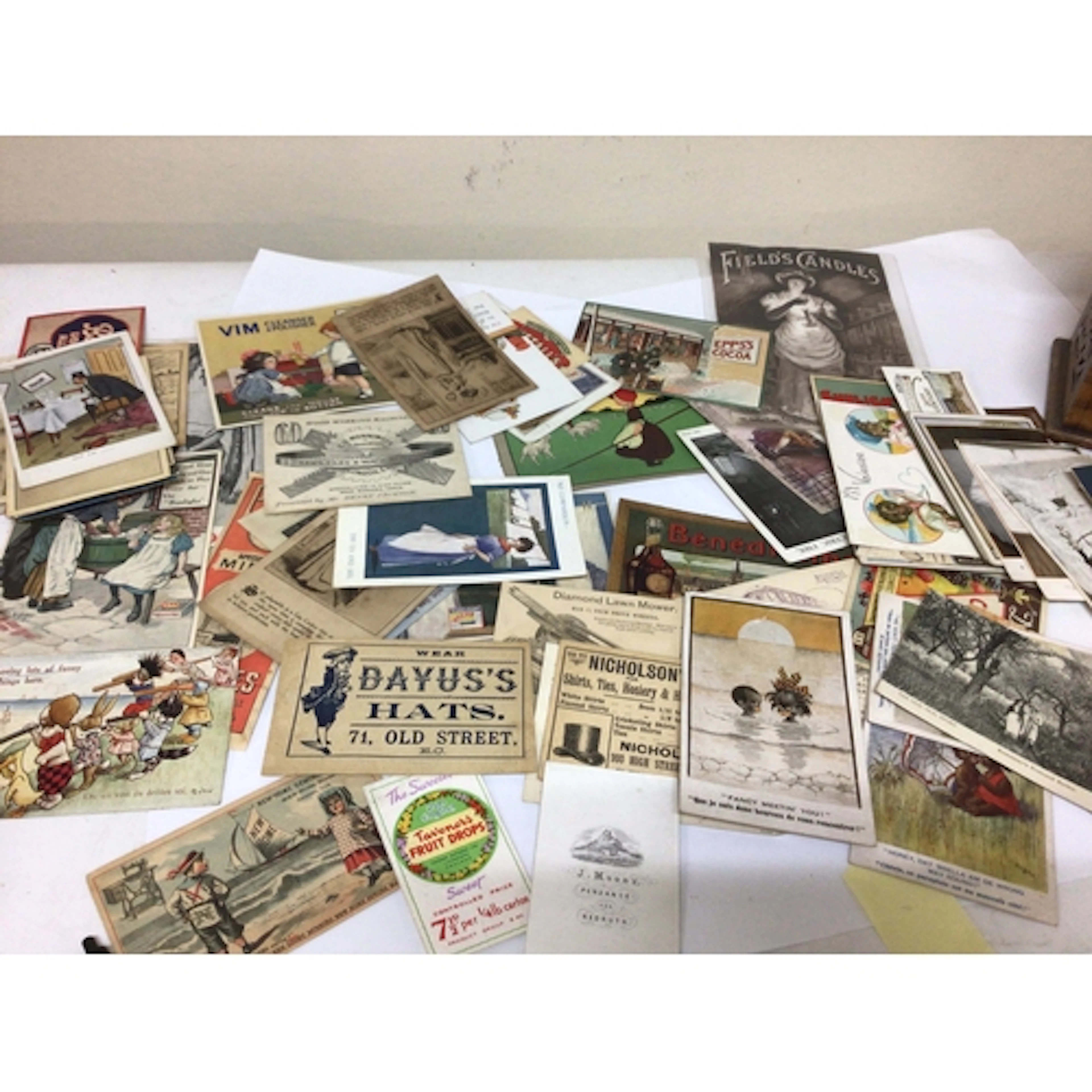 A box containing vintage commercial postcards and Vict...