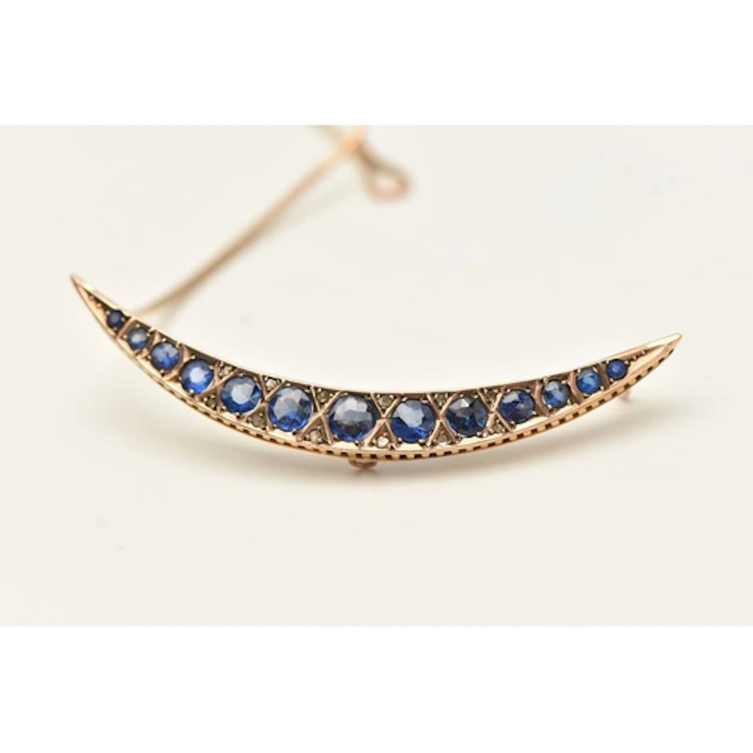A 9CT YELLOW EARLY 20TH CENTURY BROOCH, a crecent brooch set...