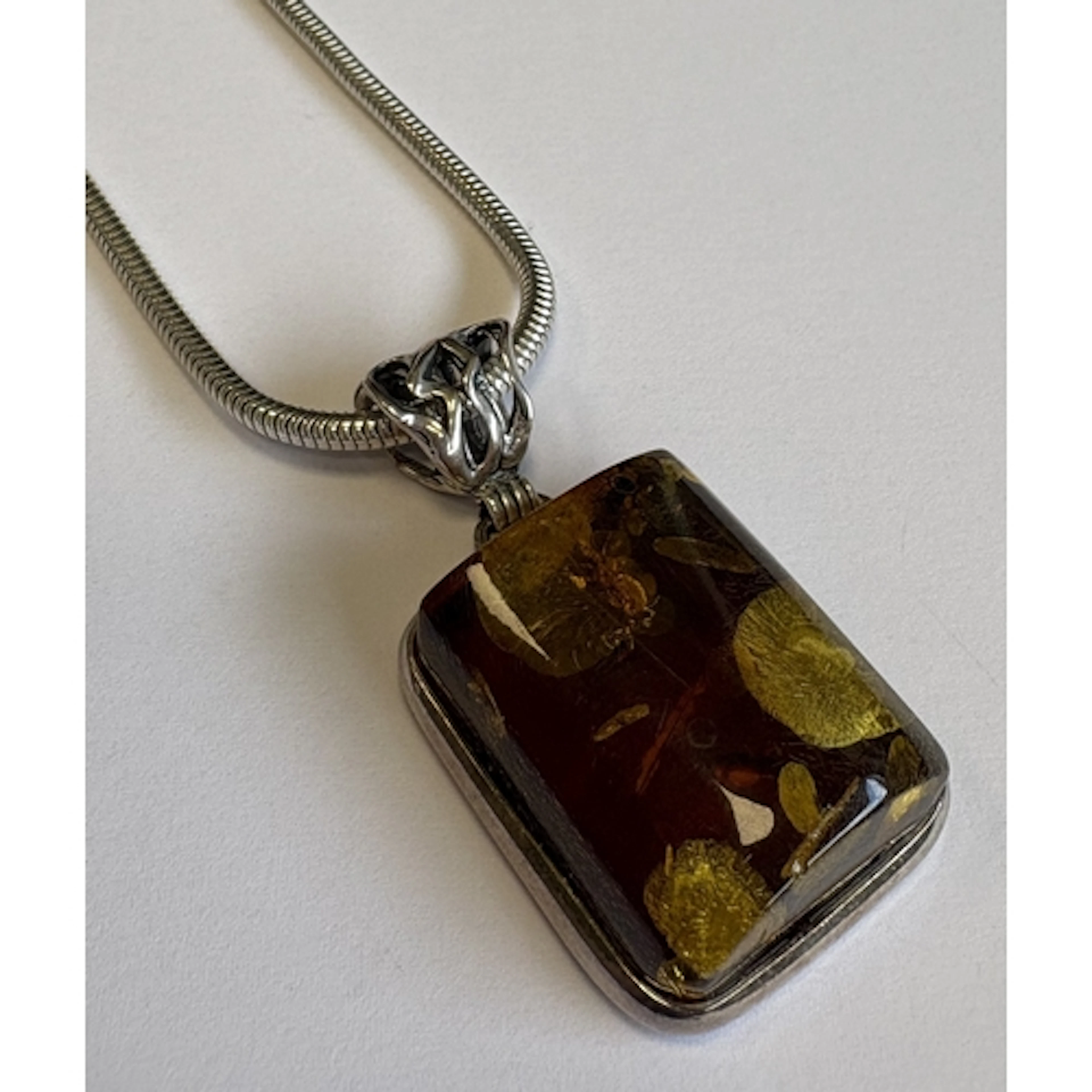A silver-mounted necklace with amber pendant. Approx. 22 gra...