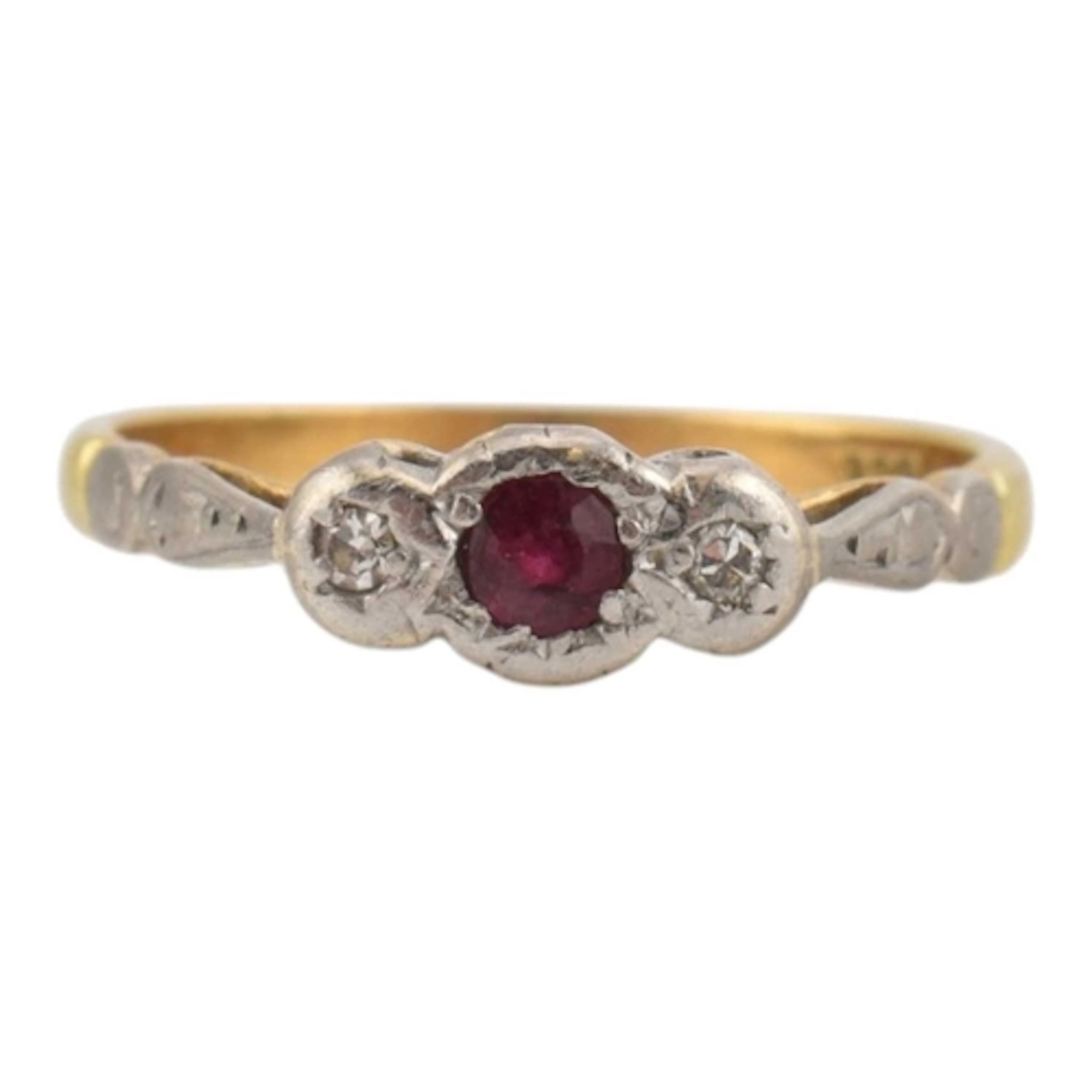 A ruby and diamond three stone ring. The ring set with a cen...