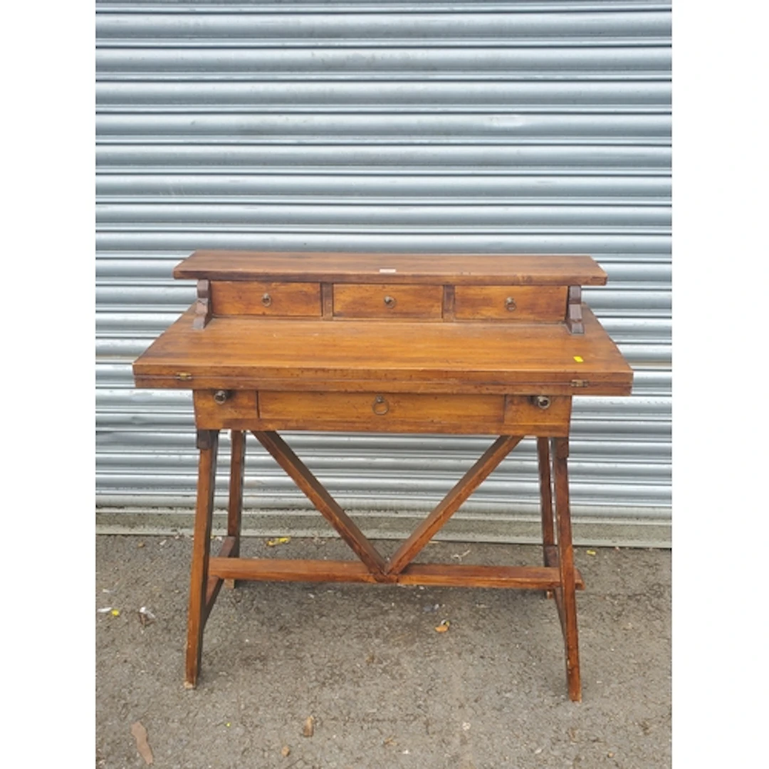 A hardwood Desk fitted three small drawers above fold-over w...