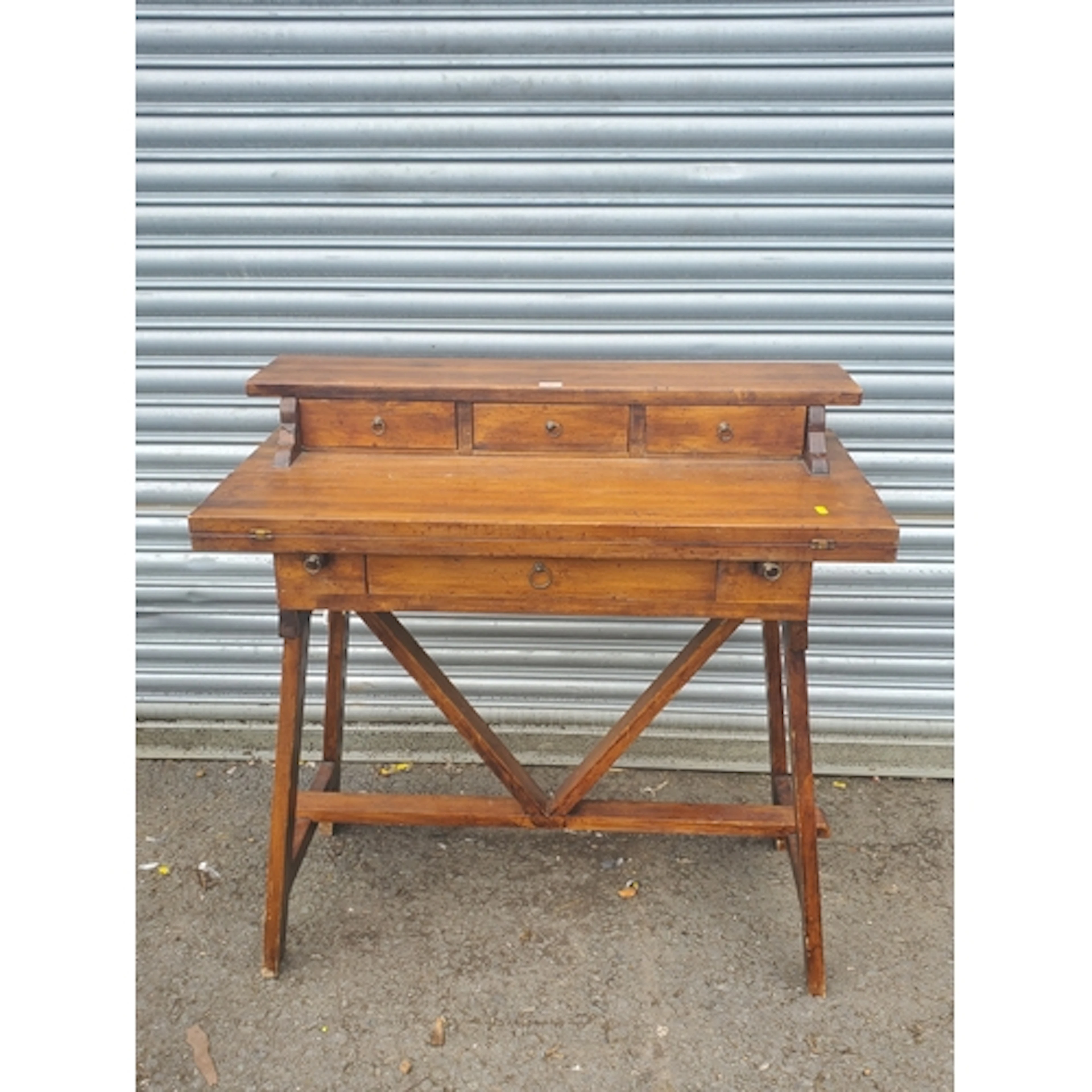 A hardwood Desk fitted three small drawers above fold-over w...