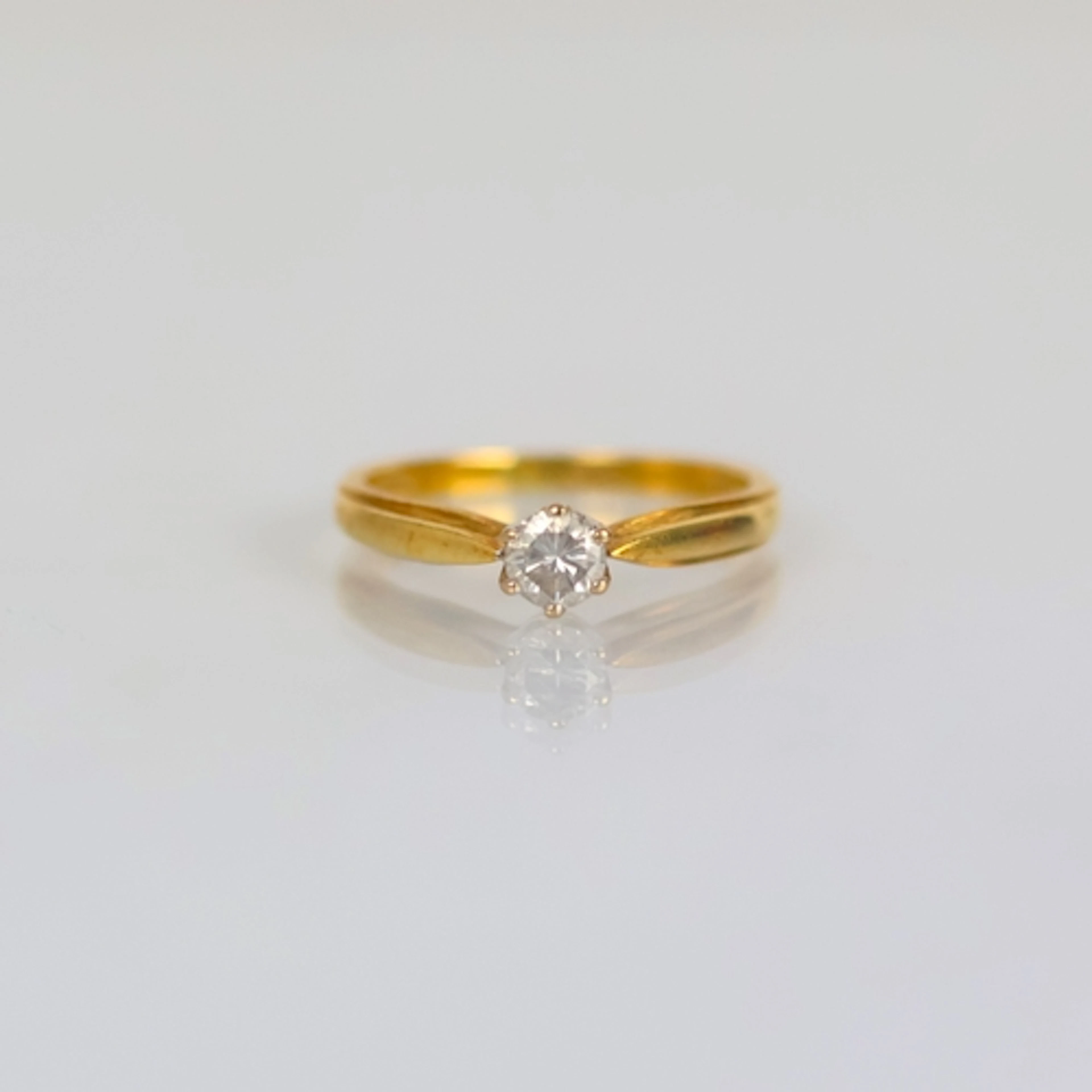 A late 20th century 18ct yellow gold diamond solitaire, the ...