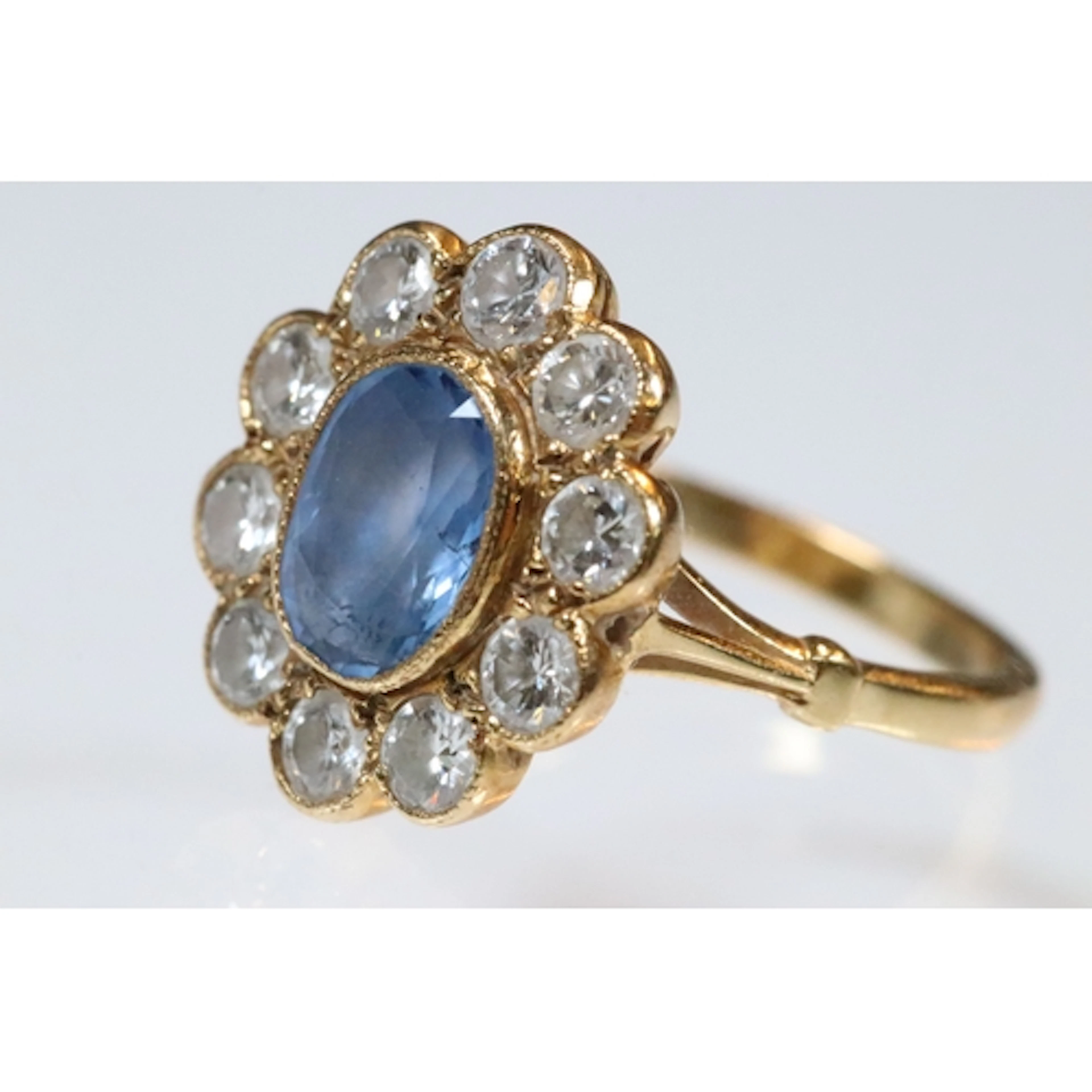 18ct gold, sapphire and diamond cluster ring. The ring being...