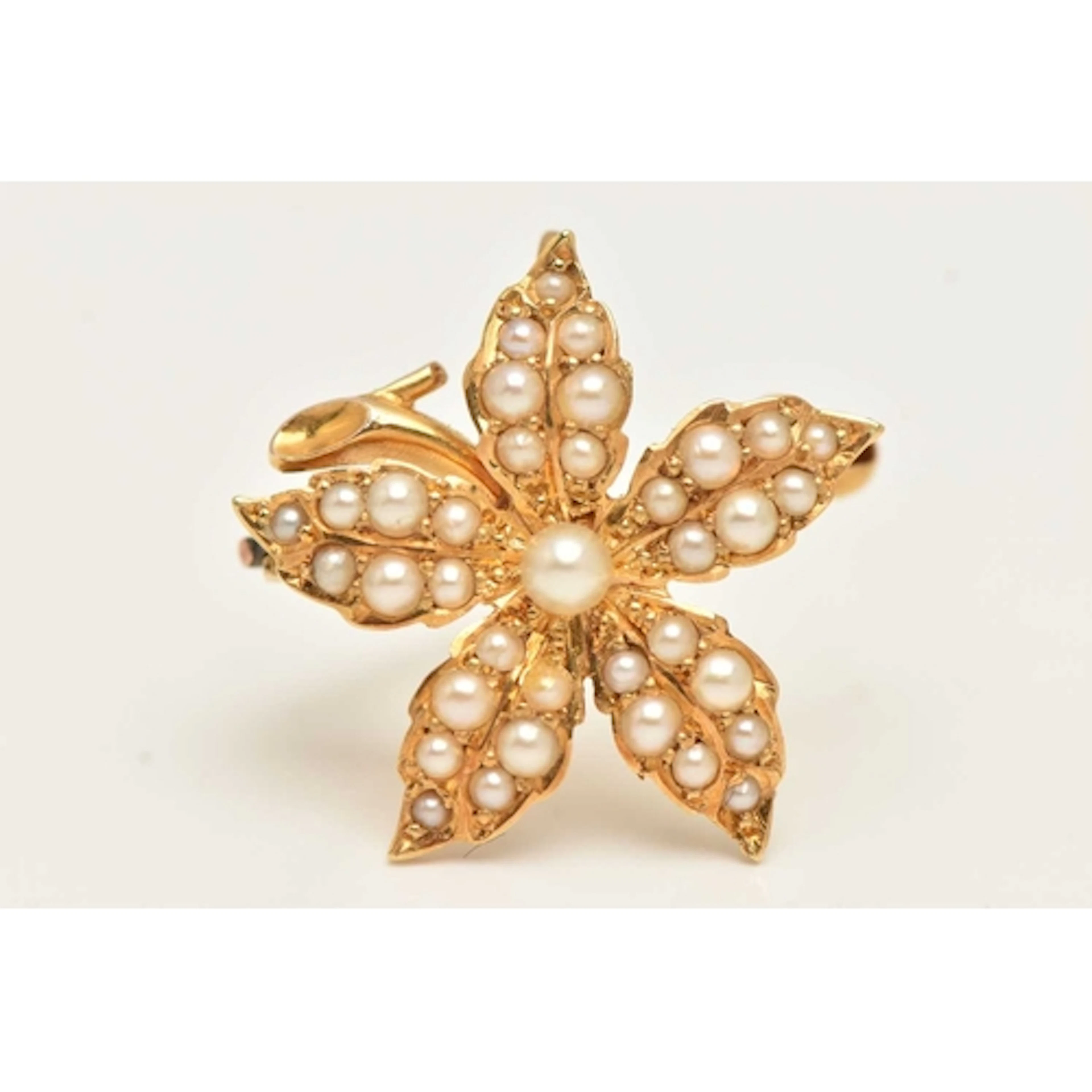 A SMALL YELLOW METAL SPLIT PEARL SET FLOWER BROOCH, fitted w...
