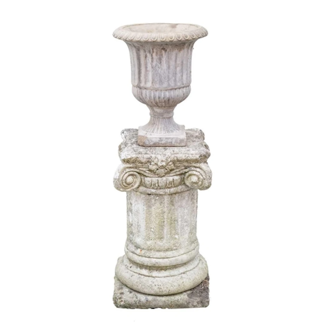 A cast stone fluted urn. Raised on associated ionic column p...