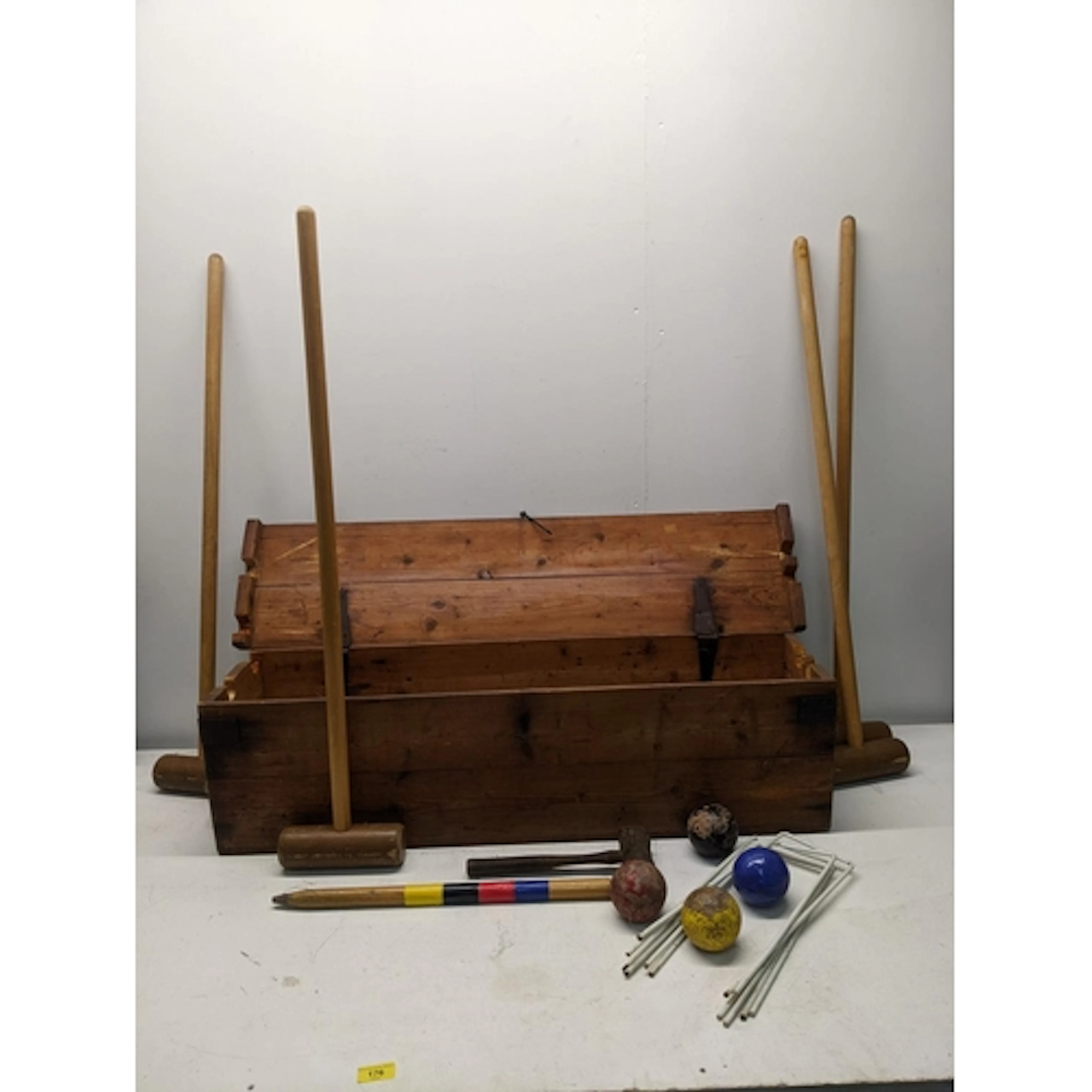 A wooden boxed croquet set comprising six white painted meta...
