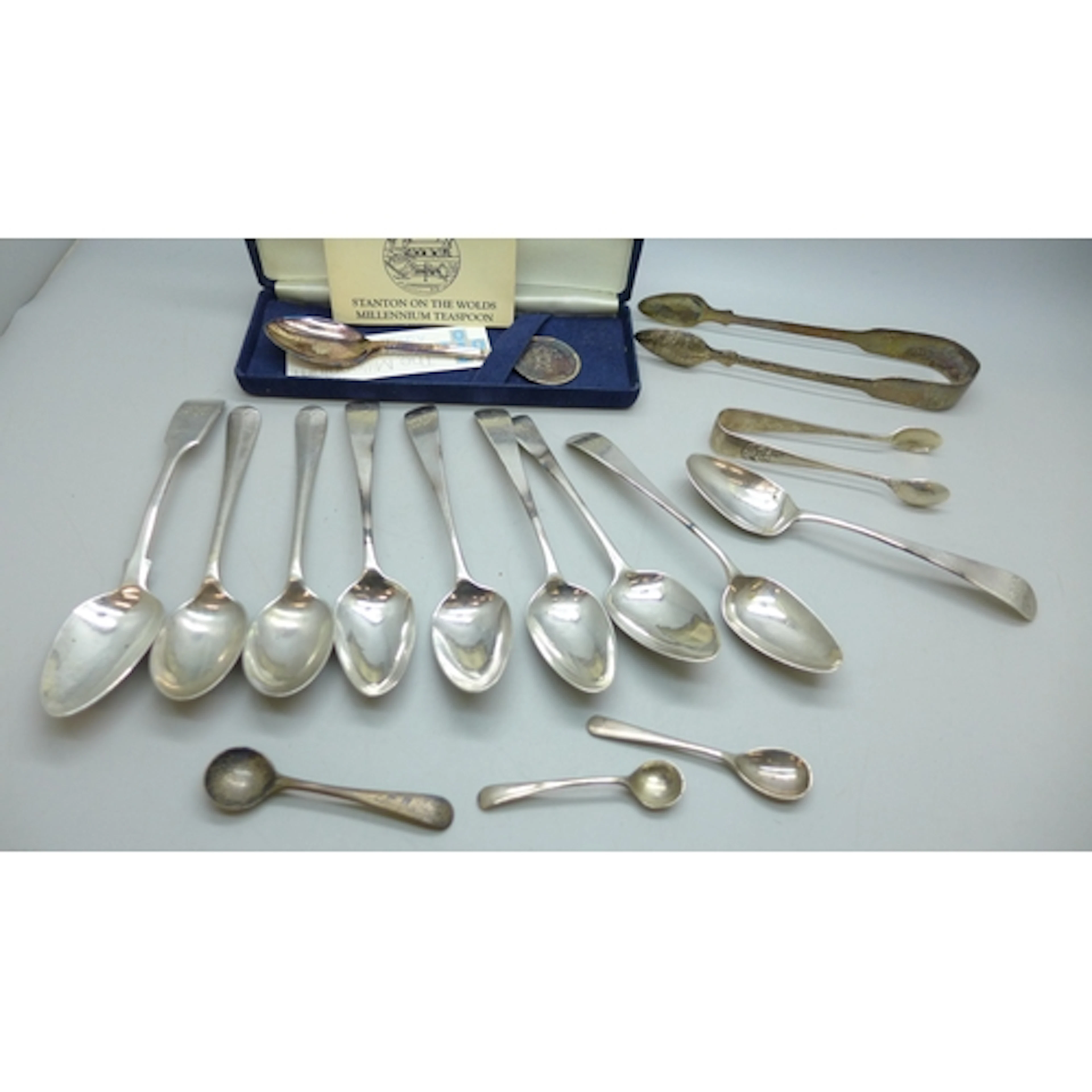 A collection of silver including sugar tongs, tea spoons, co...