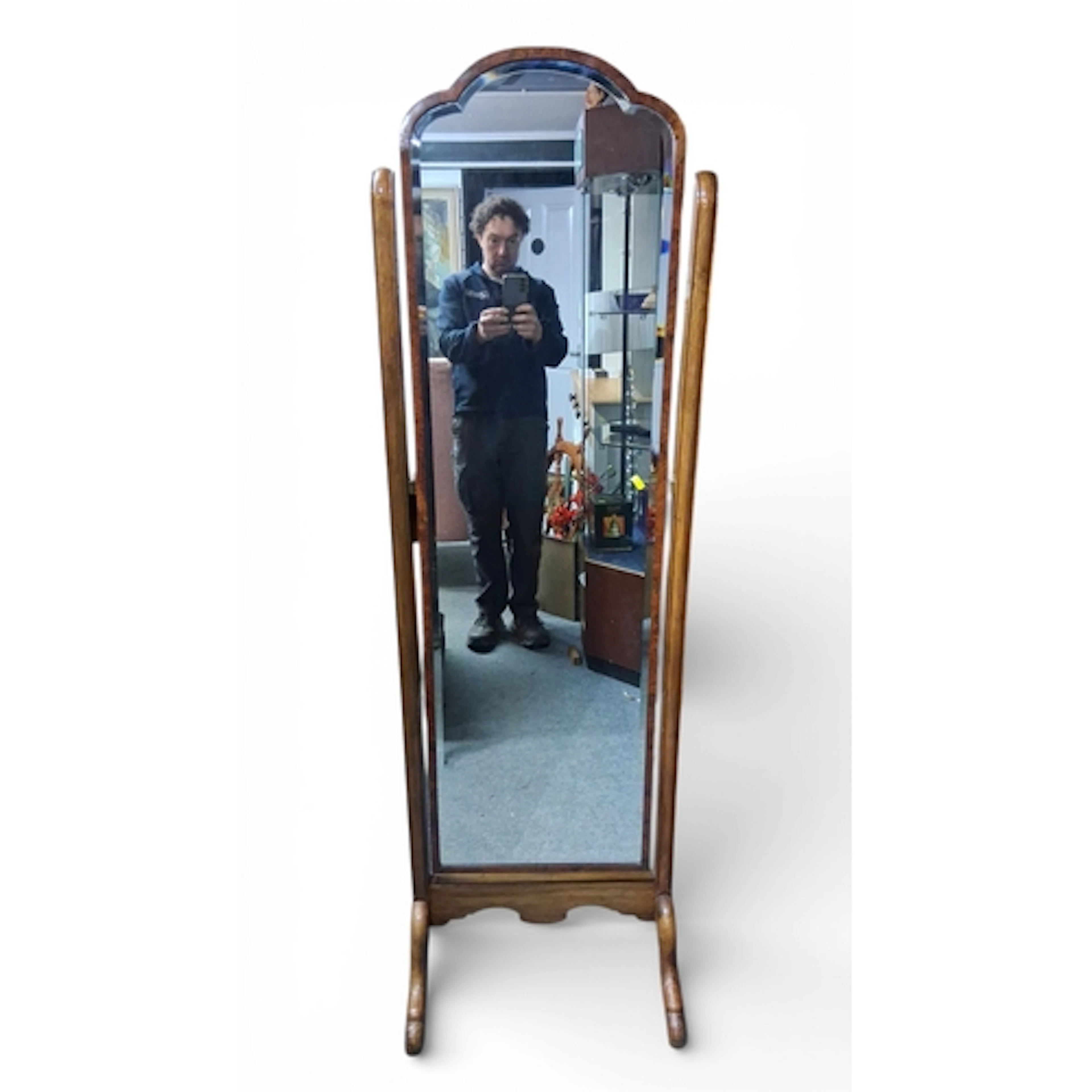 A freestanding walnut-veneered cheval mirror, the arched pla...