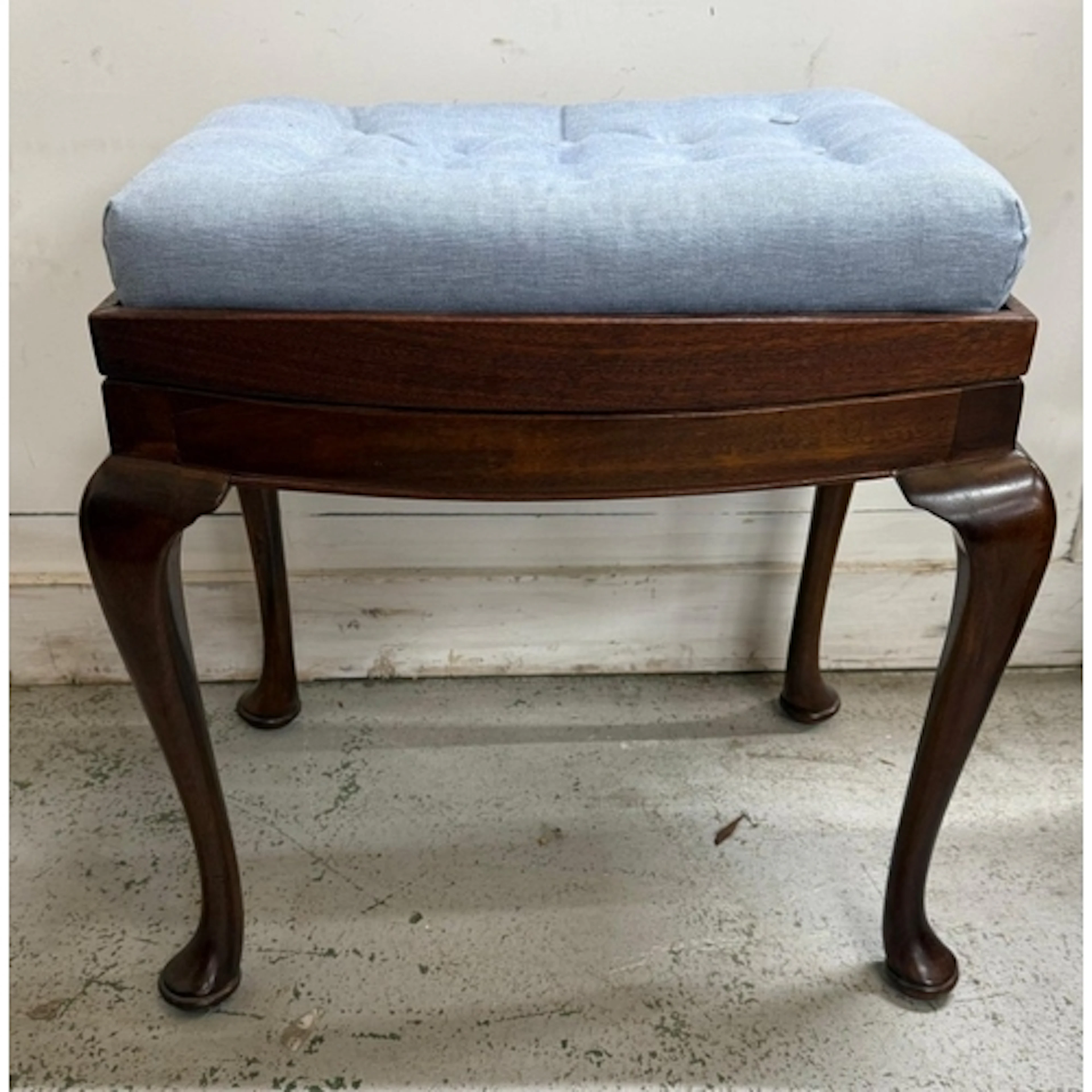 A pale blue upholstered button tufted mahogany piano stool...