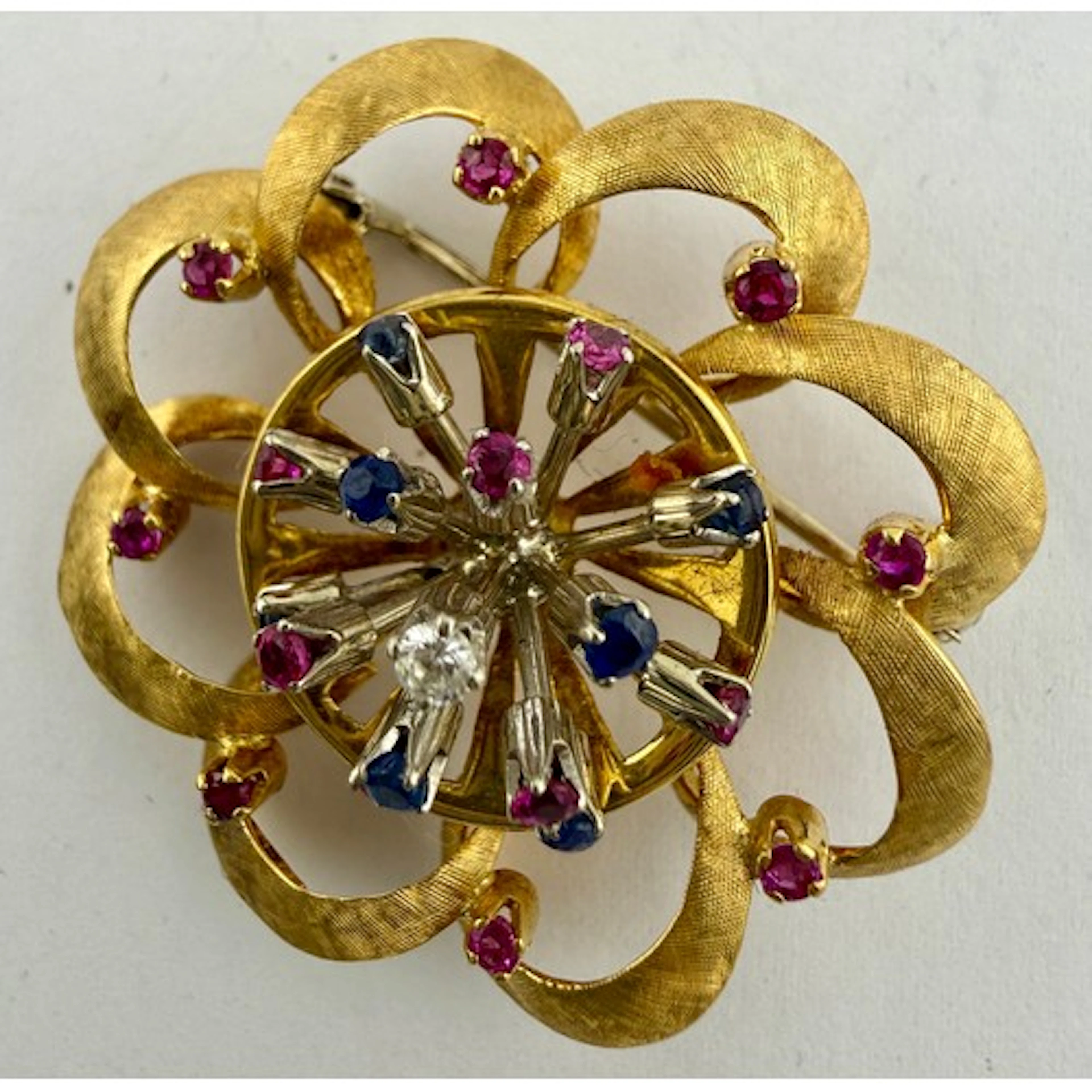 An 18 carat yellow and white gold brooch set with sapphires,...