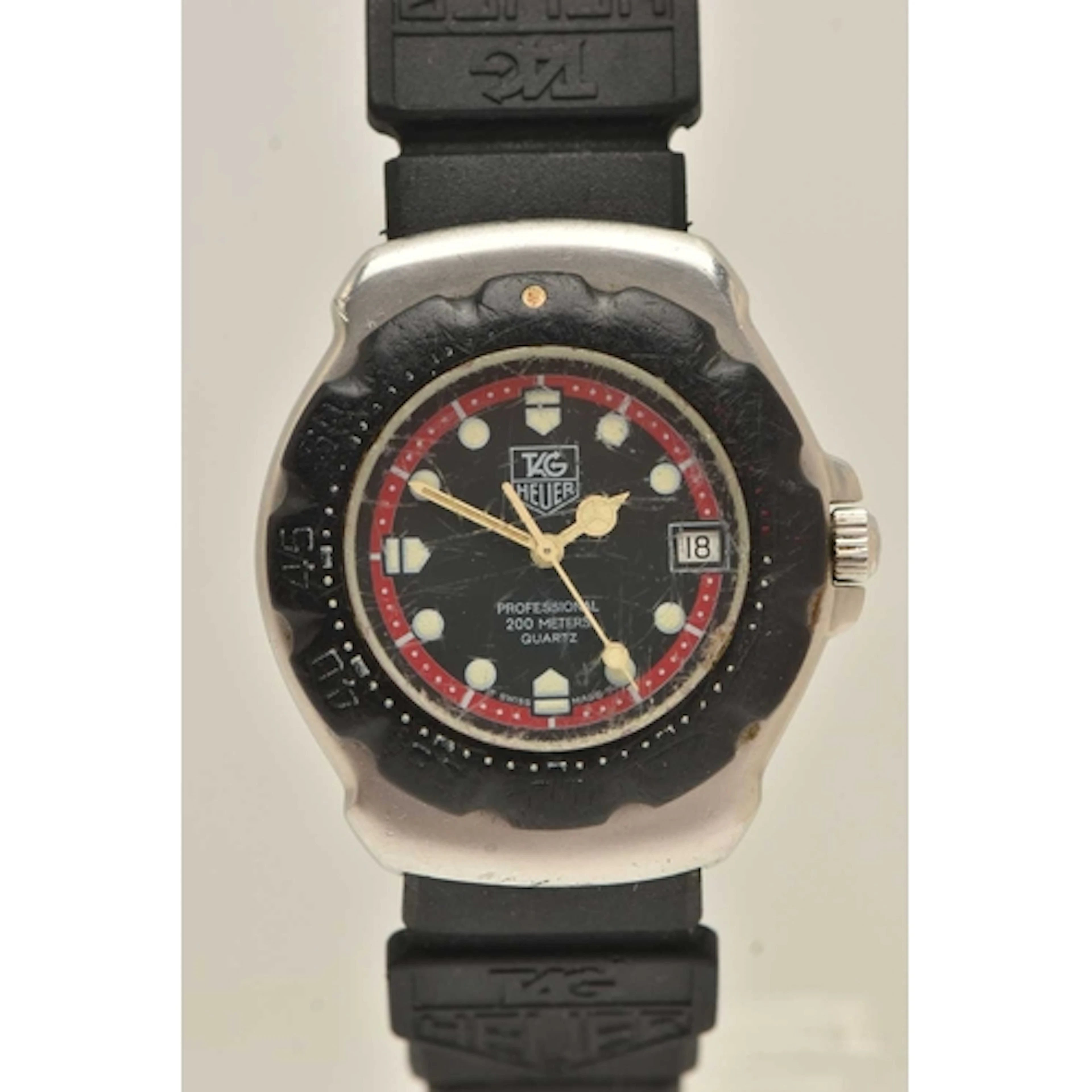 A TAG HEUER WRISTWATCH, quartz movement, round black dial si...