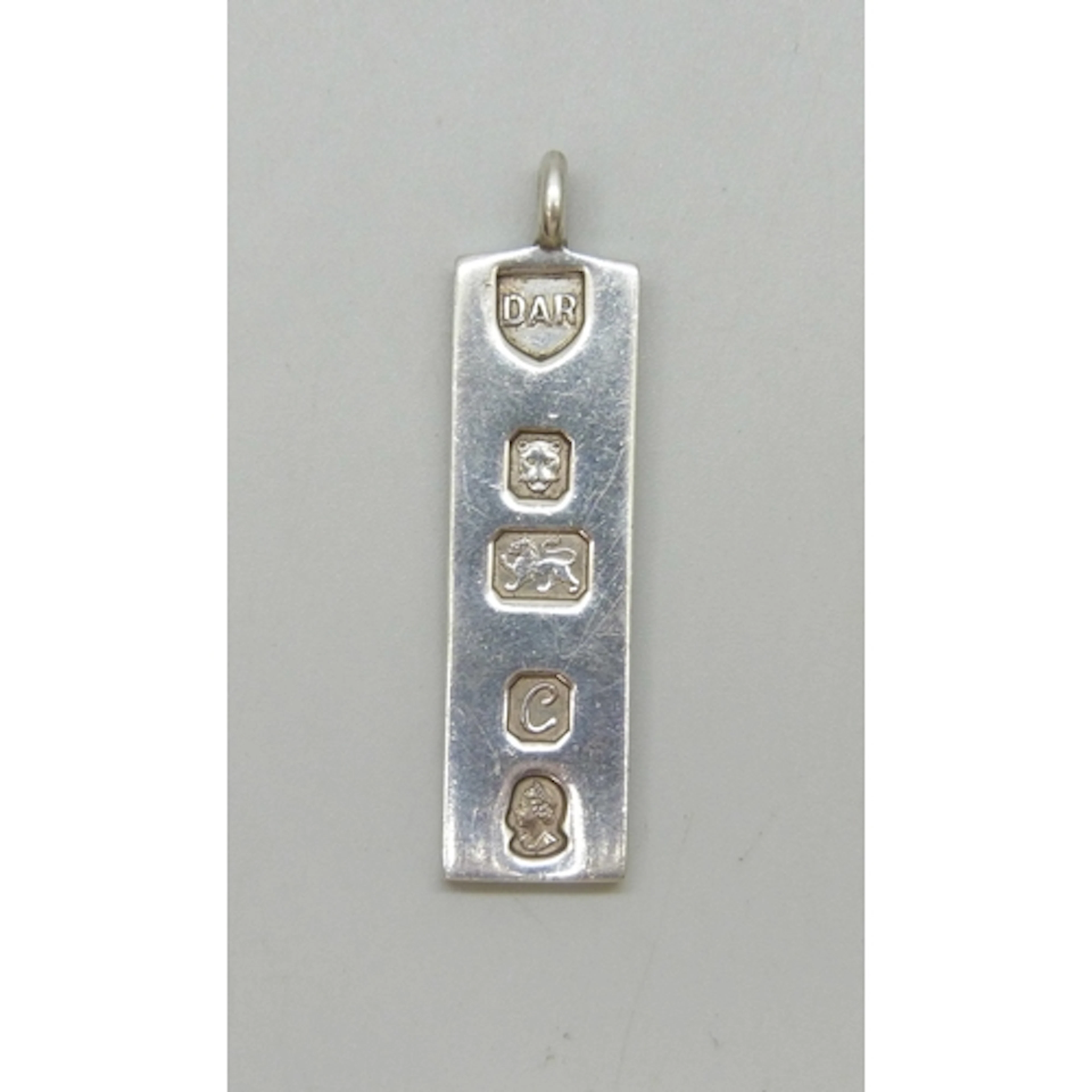 A silver ingot necklace pendant, London, 1977, 5cm including...