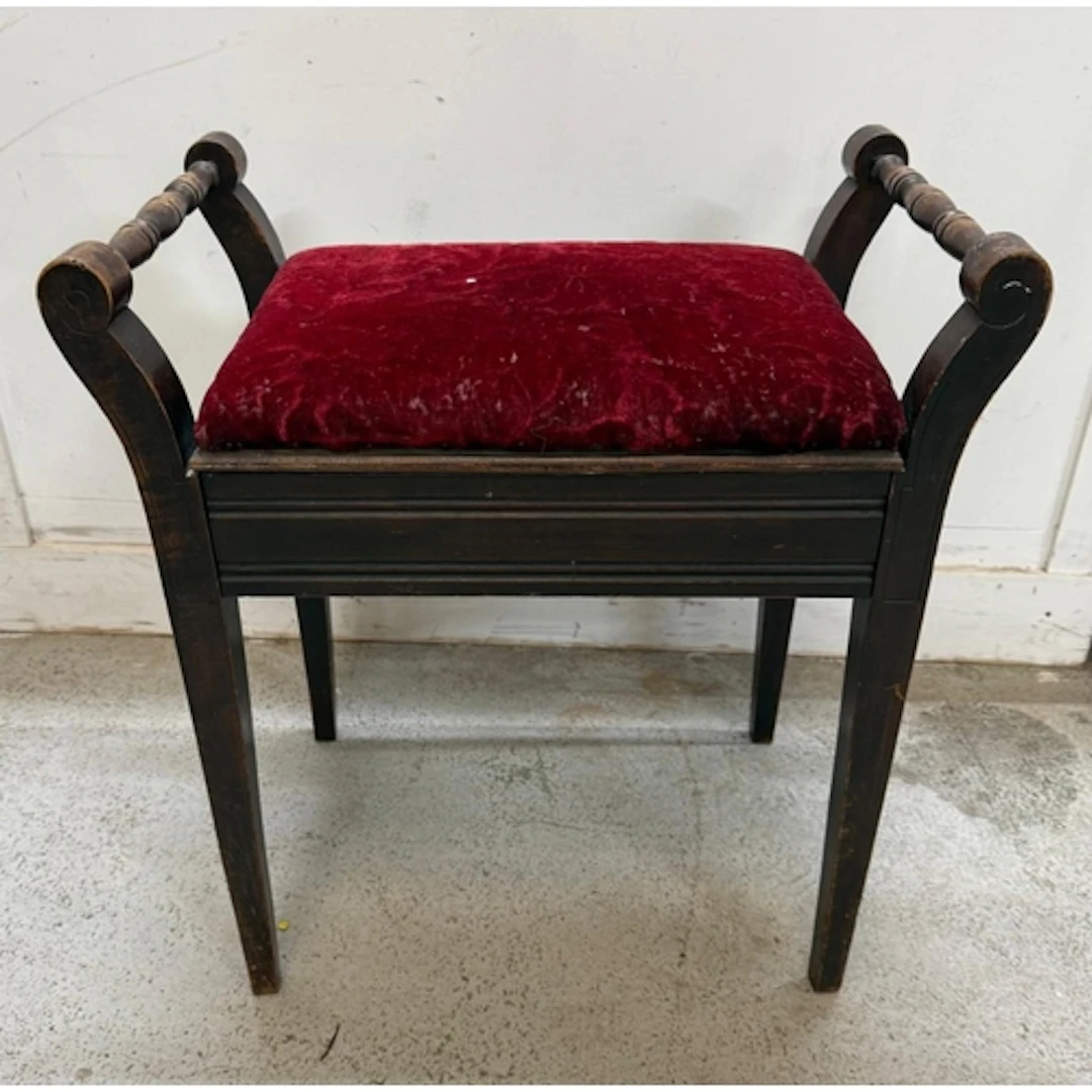 An oak piano stool upholstered in red floral velvet