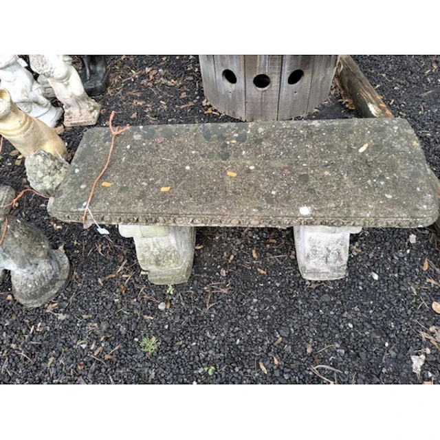 A CONCRETE GARDEN BENCH with scrolled supports, 96cm wide c...