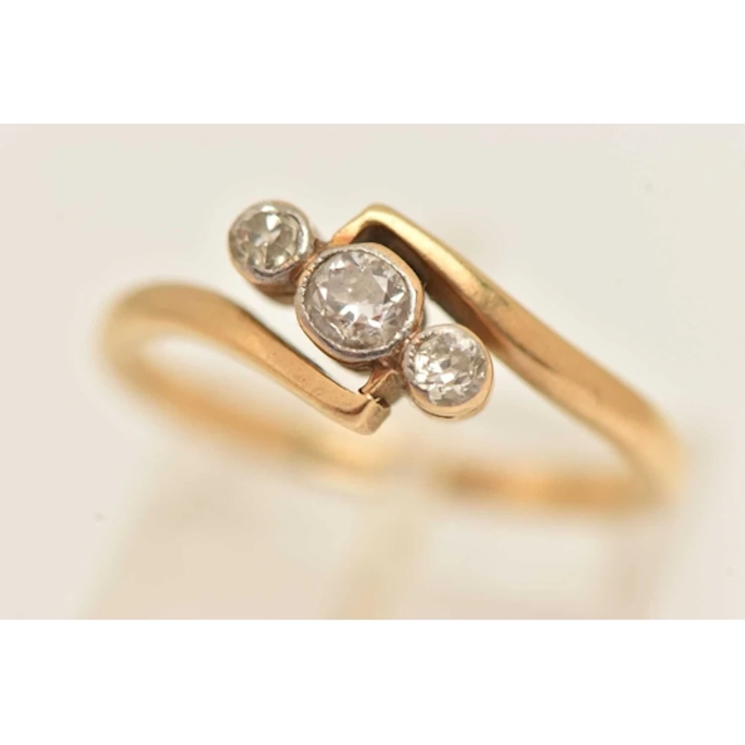 A YELLOW METAL THREE STONE DIAMOND RING, three old cut diamo...