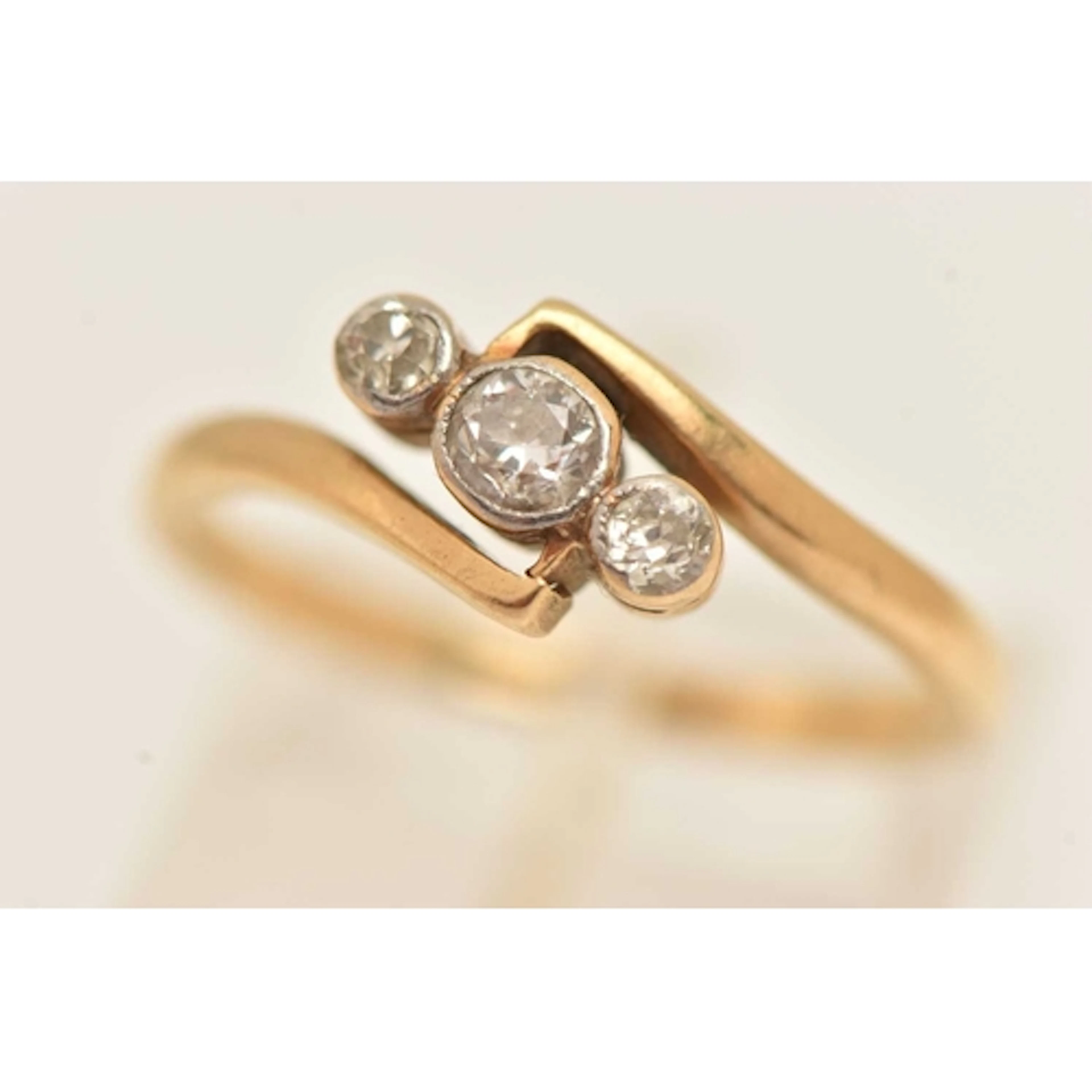 A YELLOW METAL THREE STONE DIAMOND RING, three old cut diamo...