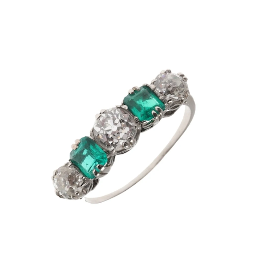 AN EMERALD AND DIAMOND FIVE STONE RING. the two octagonal st...