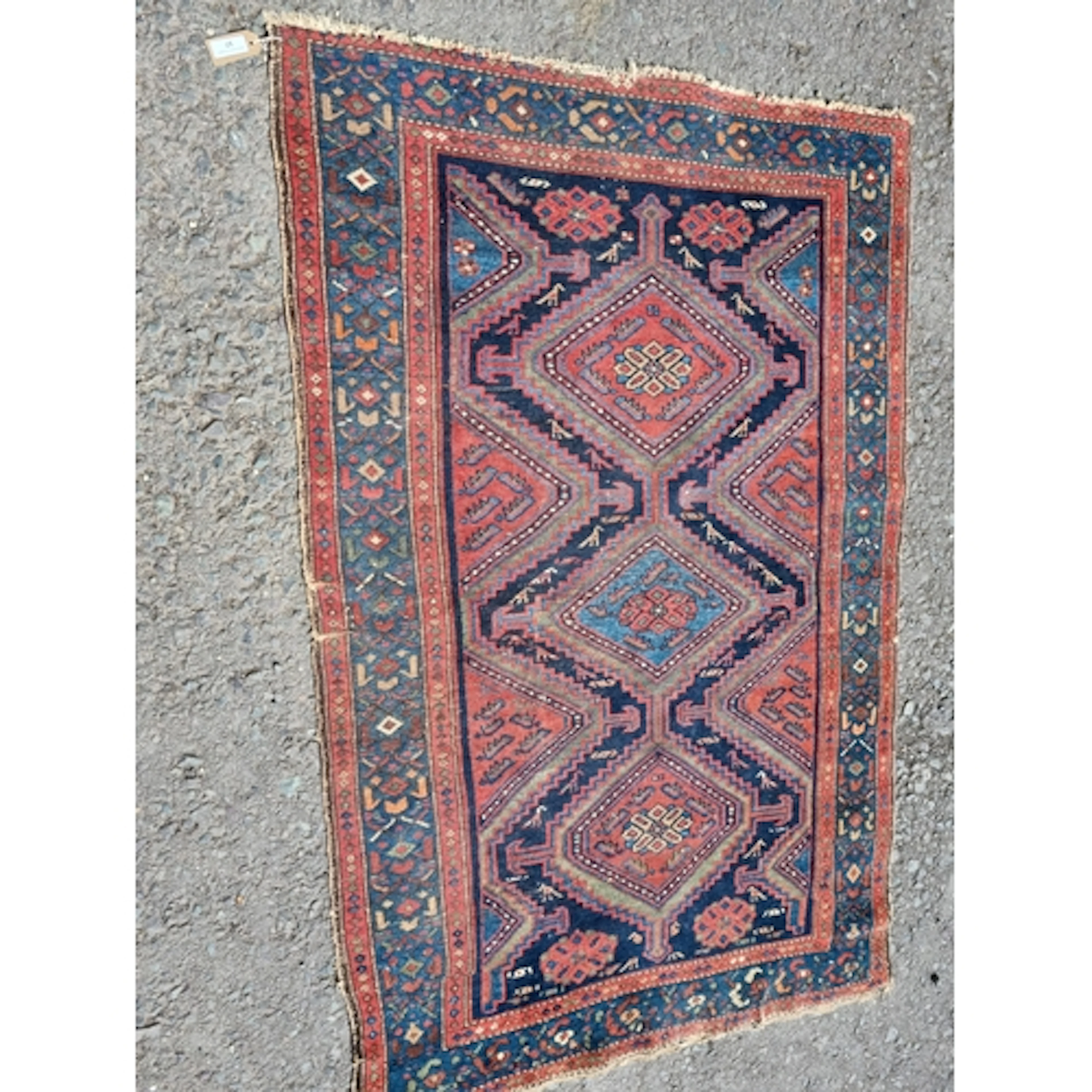 An antique bordered Kazak Rug with triple lozenge on a blue,...