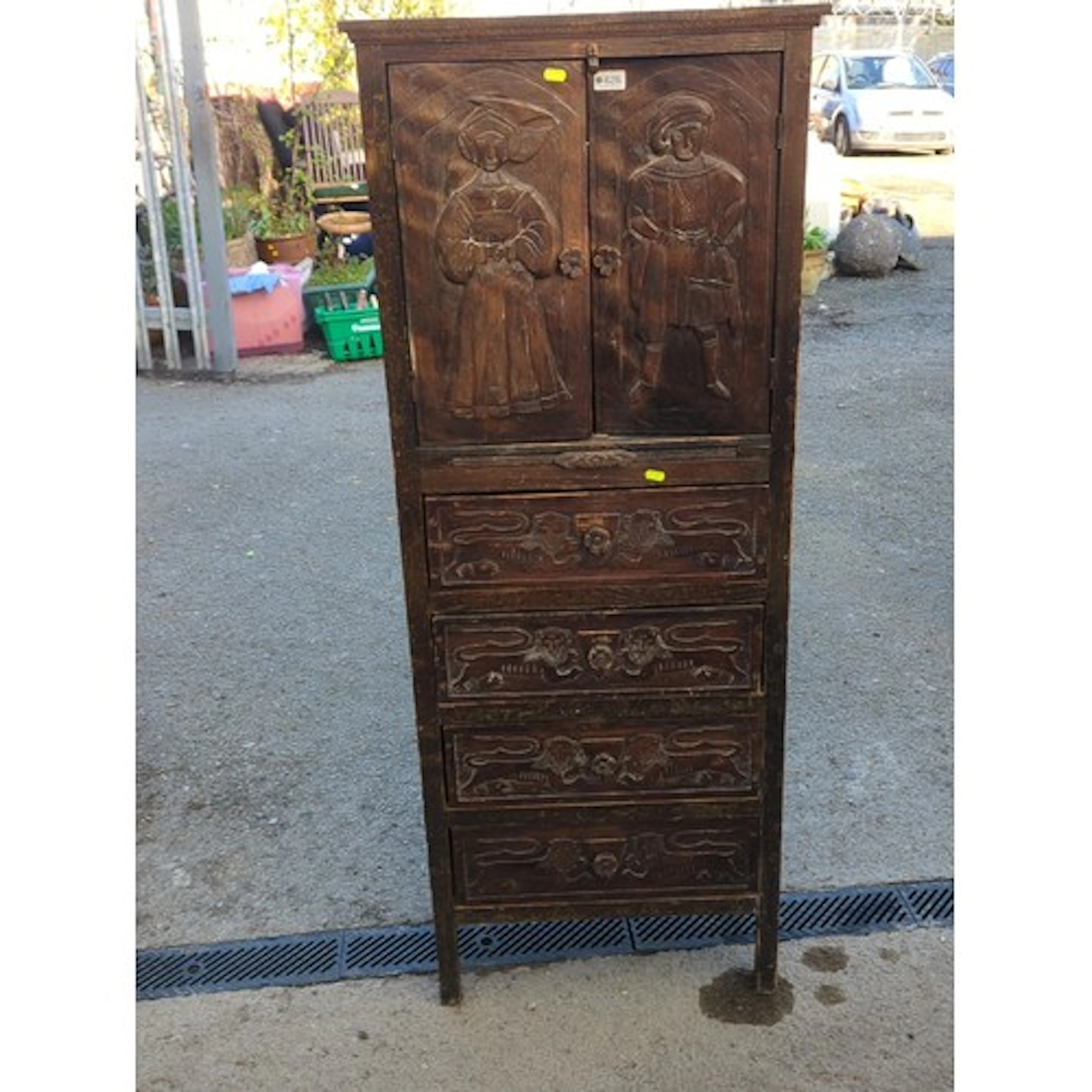 A tall carved oak cabinet-on-chest, the upper doors decorate...