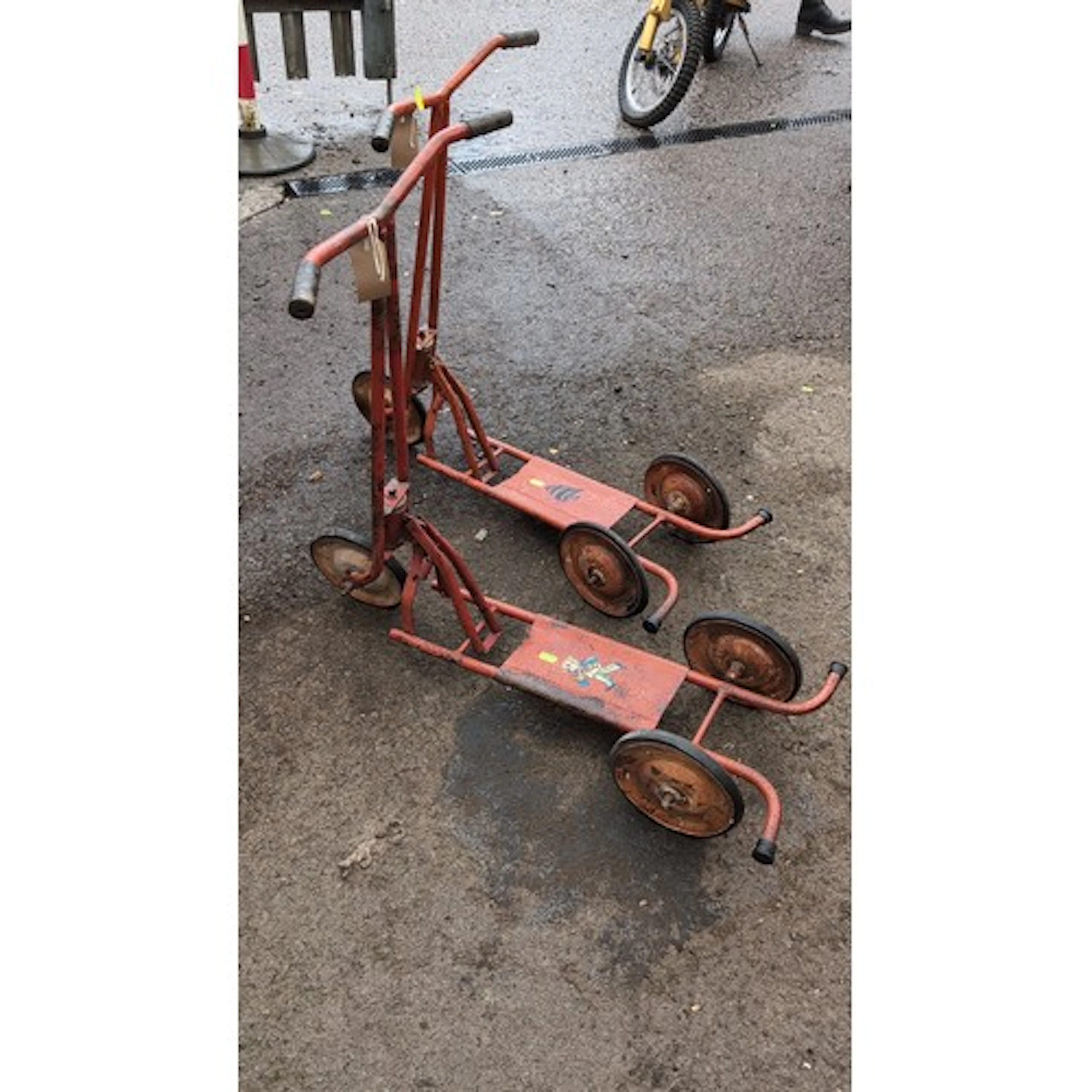 A pair of mid-20th-century children’s steel ride-on scooters...