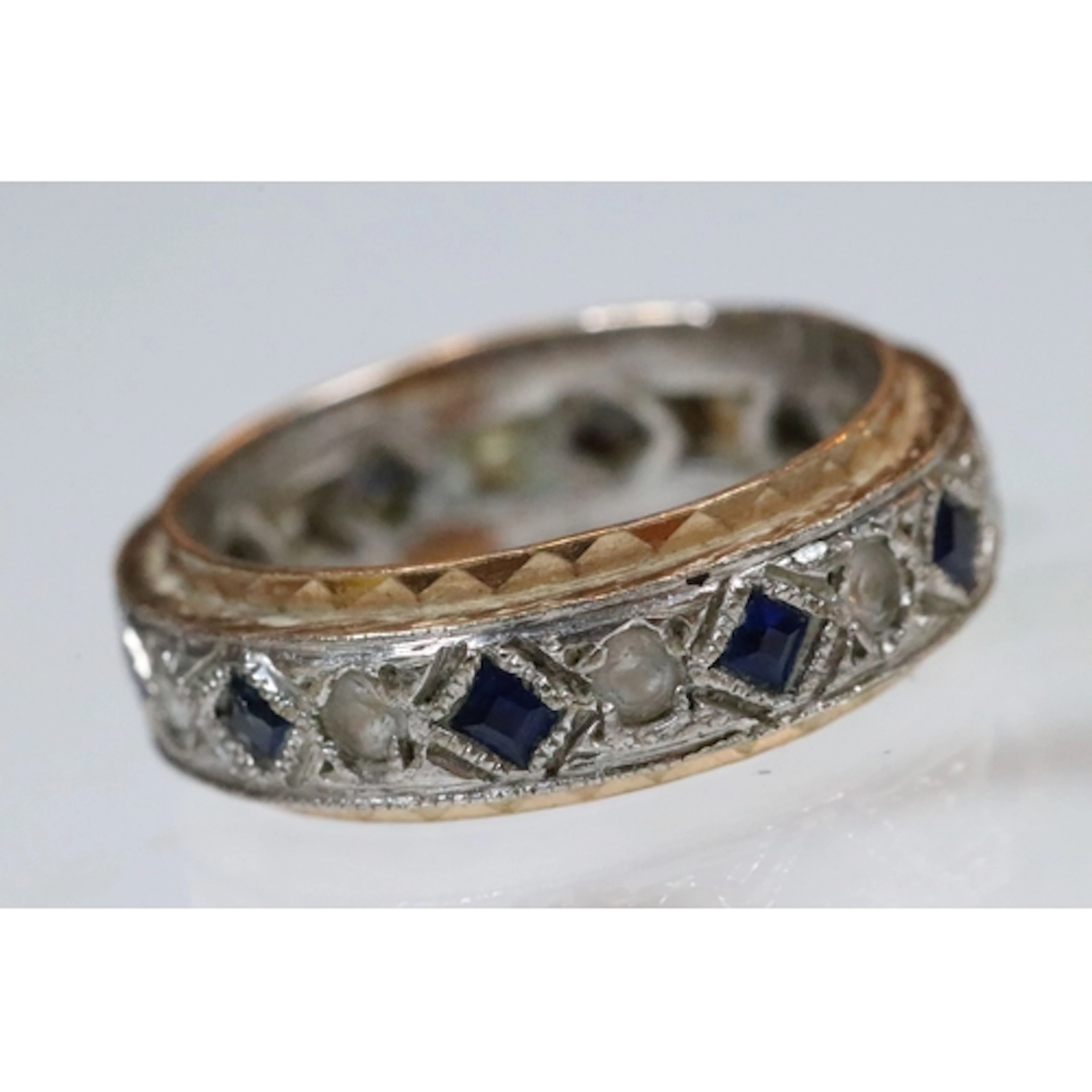 Two tone blue sapphire and white stone eternity ring. Unmark...