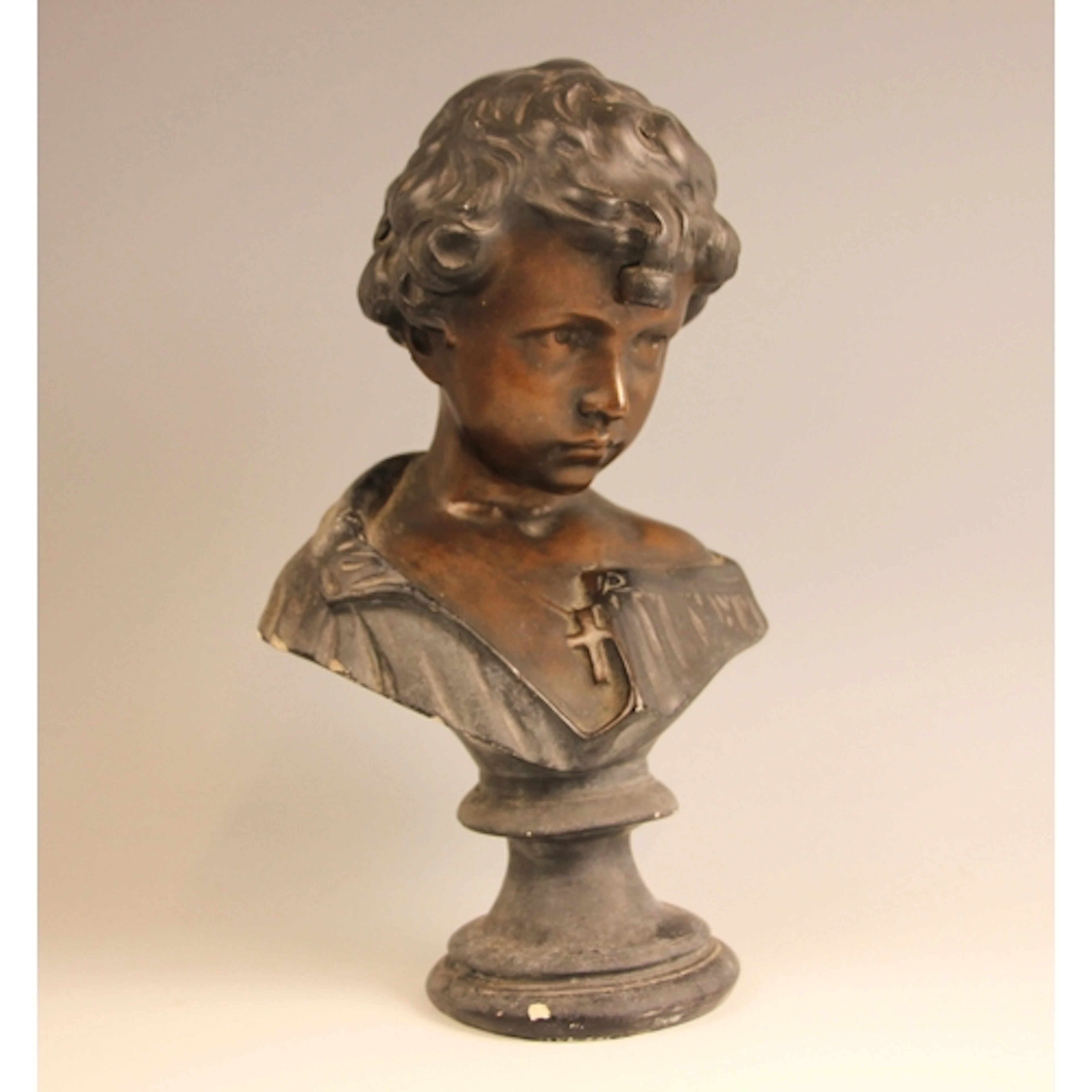 A bronze patinated plaster bust modelled as a child wearing ...