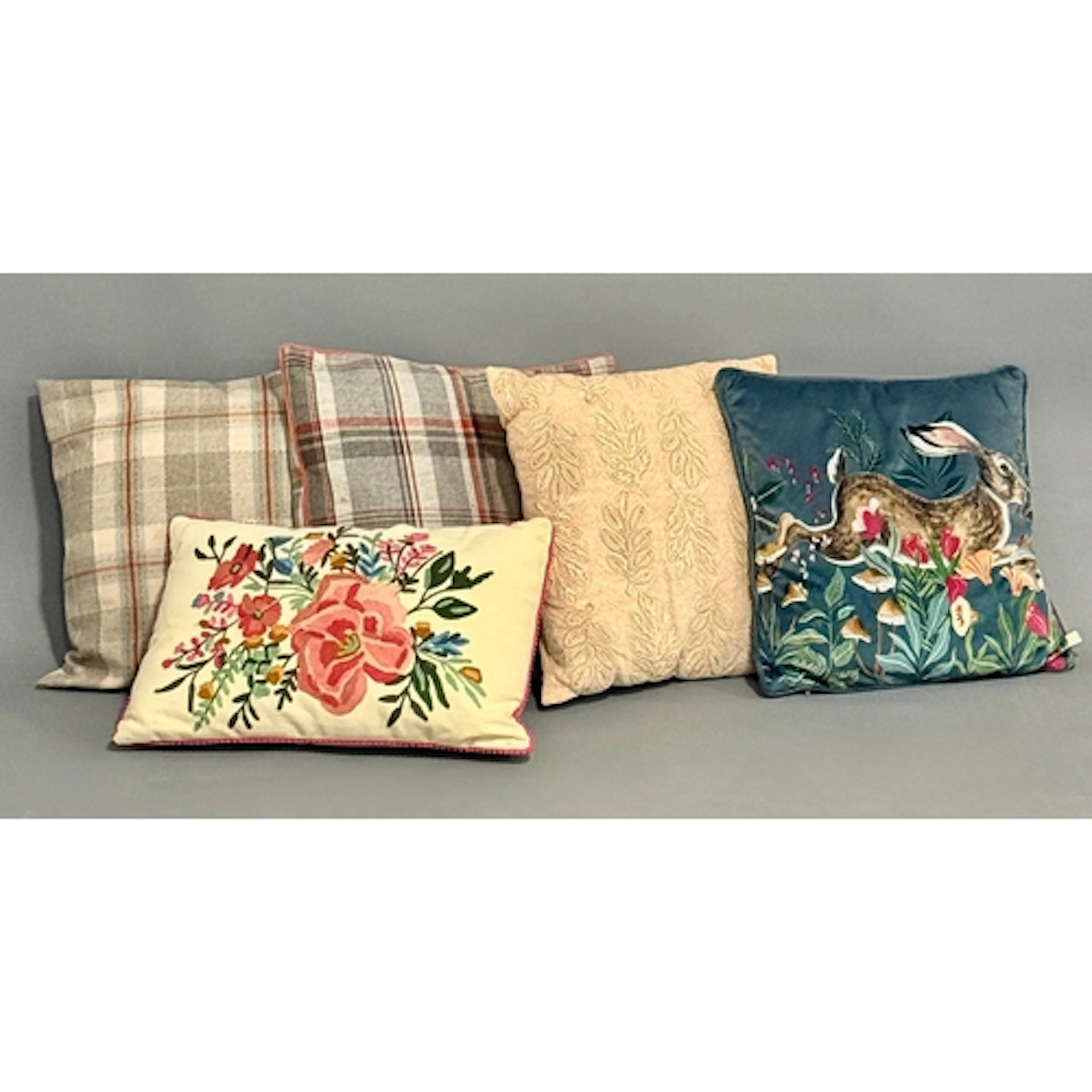 Five cushions; one teal velvet with a bright printed running...