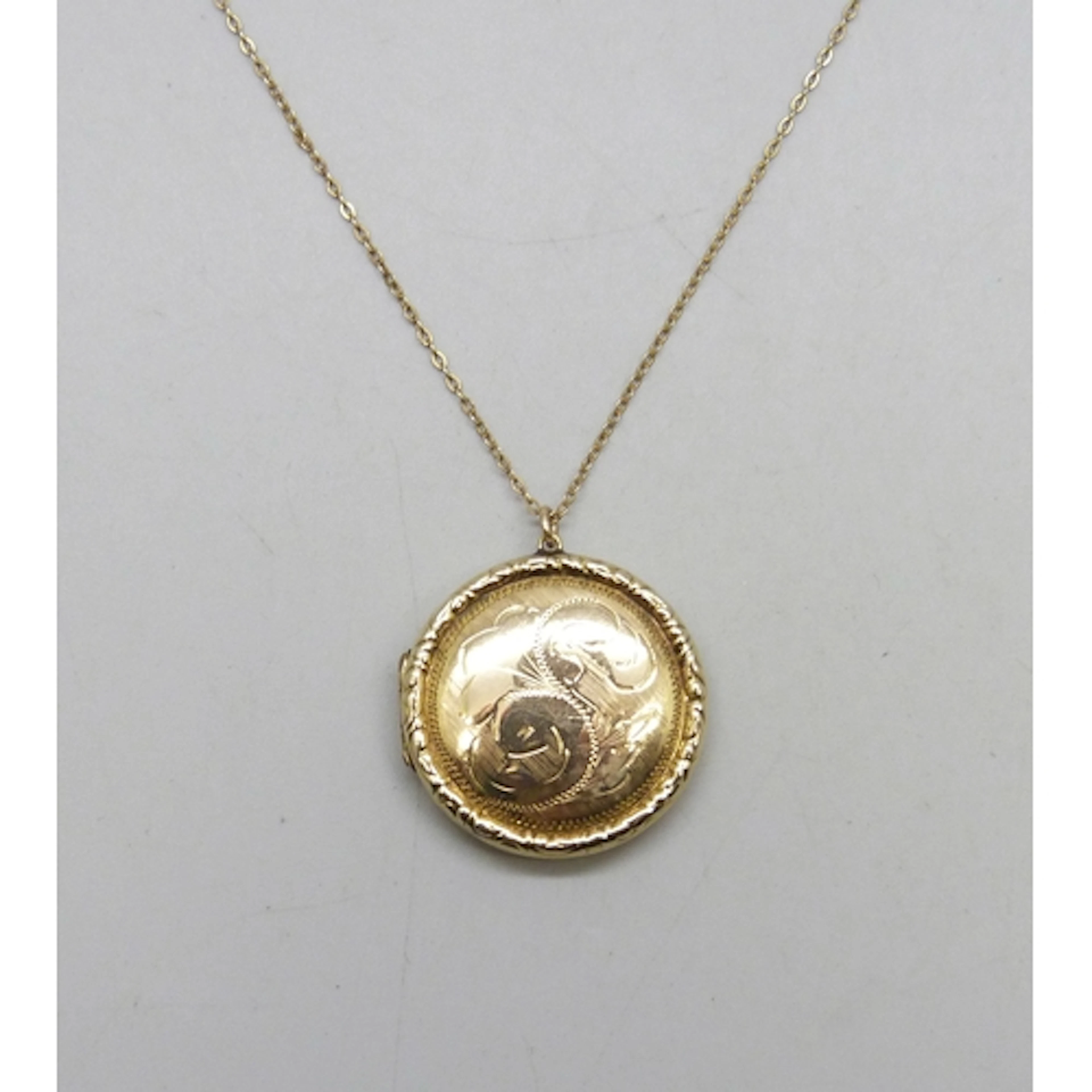A 9ct gold back and front locket, 3.3cm including bail, on a...