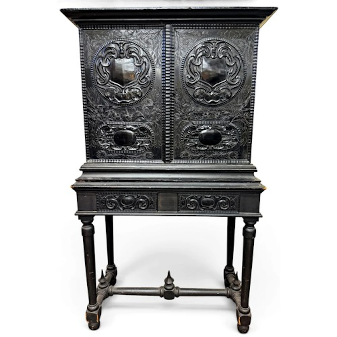 An ebony-veneered cabinet incorporating a pair of richly car...