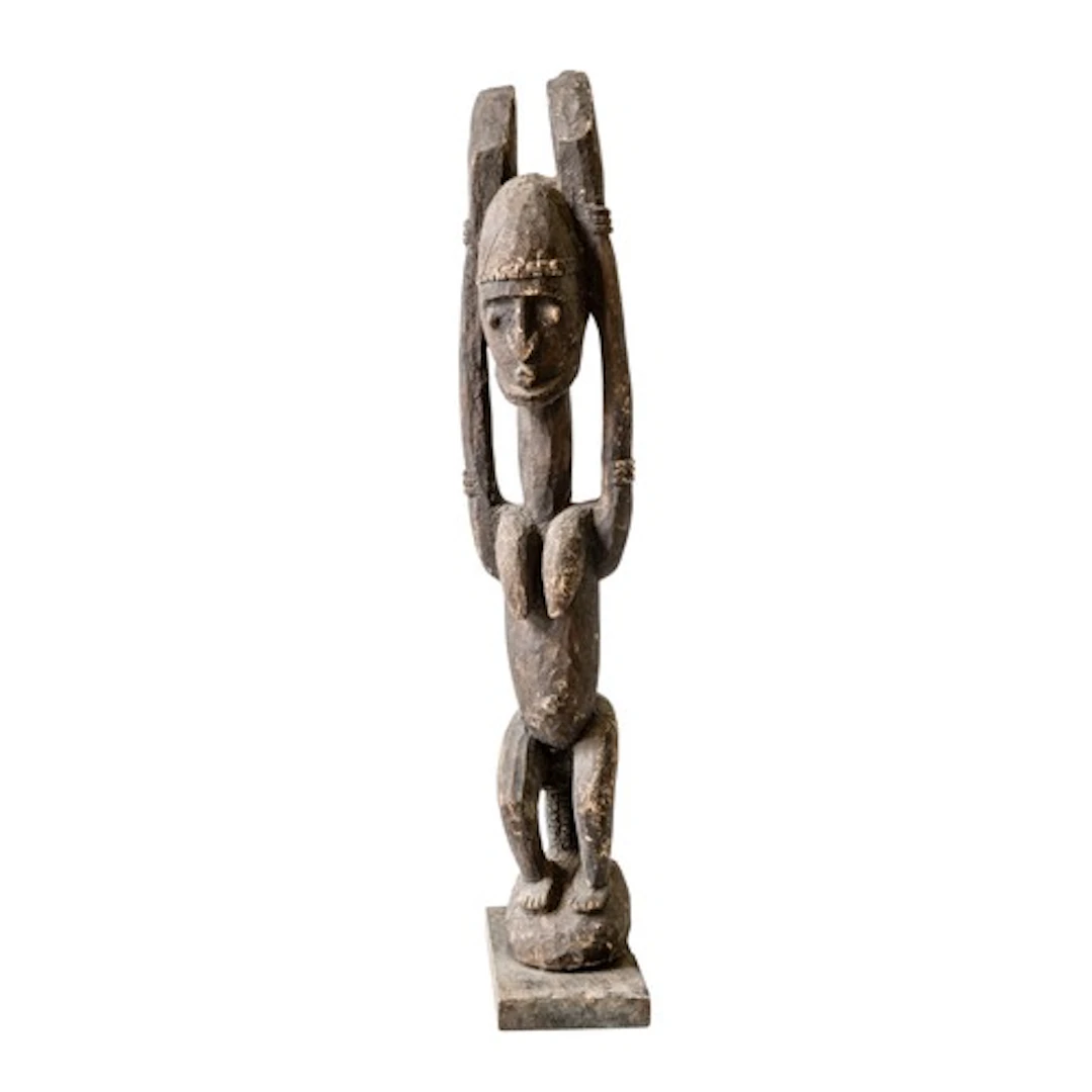 A DOGON TELLEM STATUE depicting a female figure, her hands h...