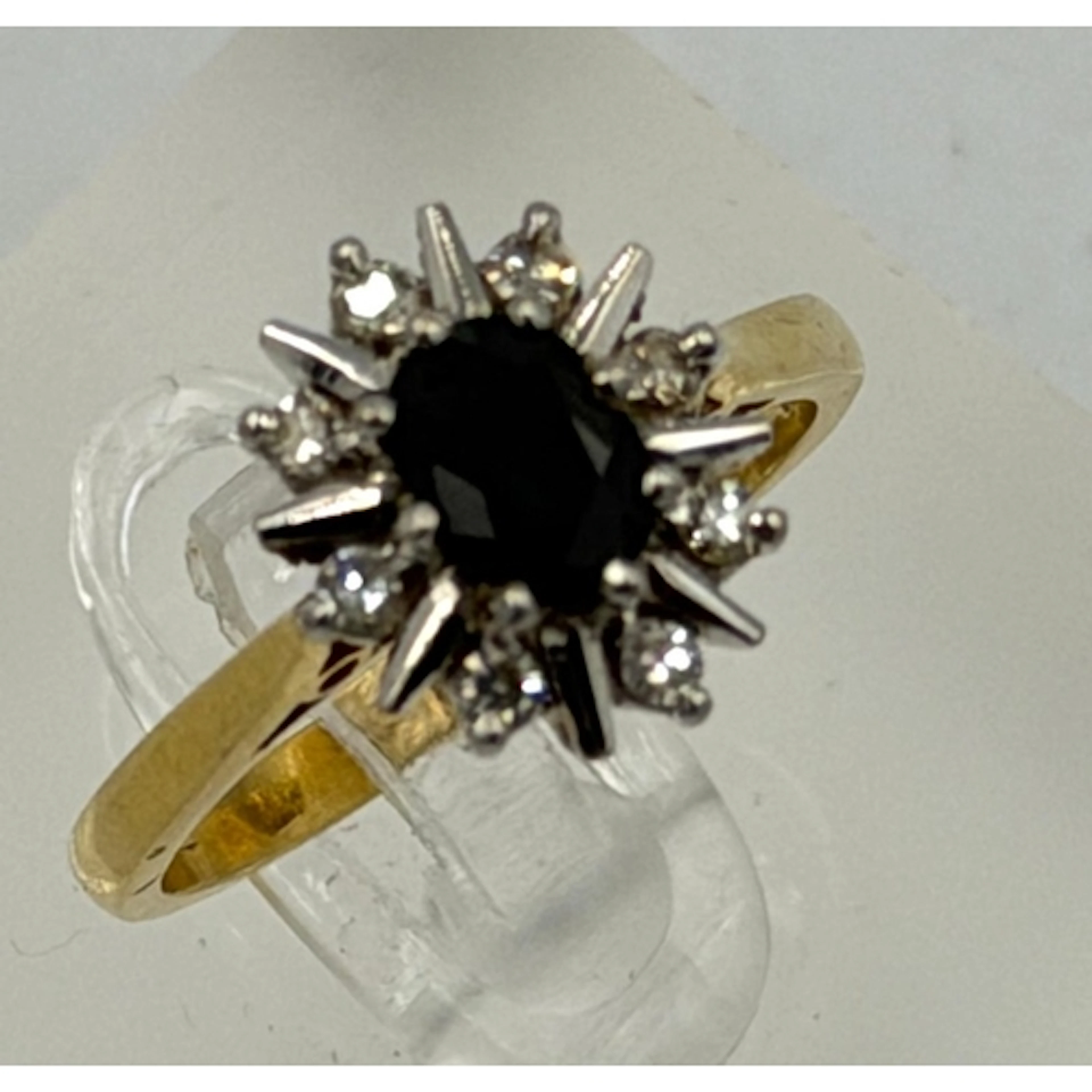 An 18ct gold sapphire and diamond cluster ring, dark centre ...