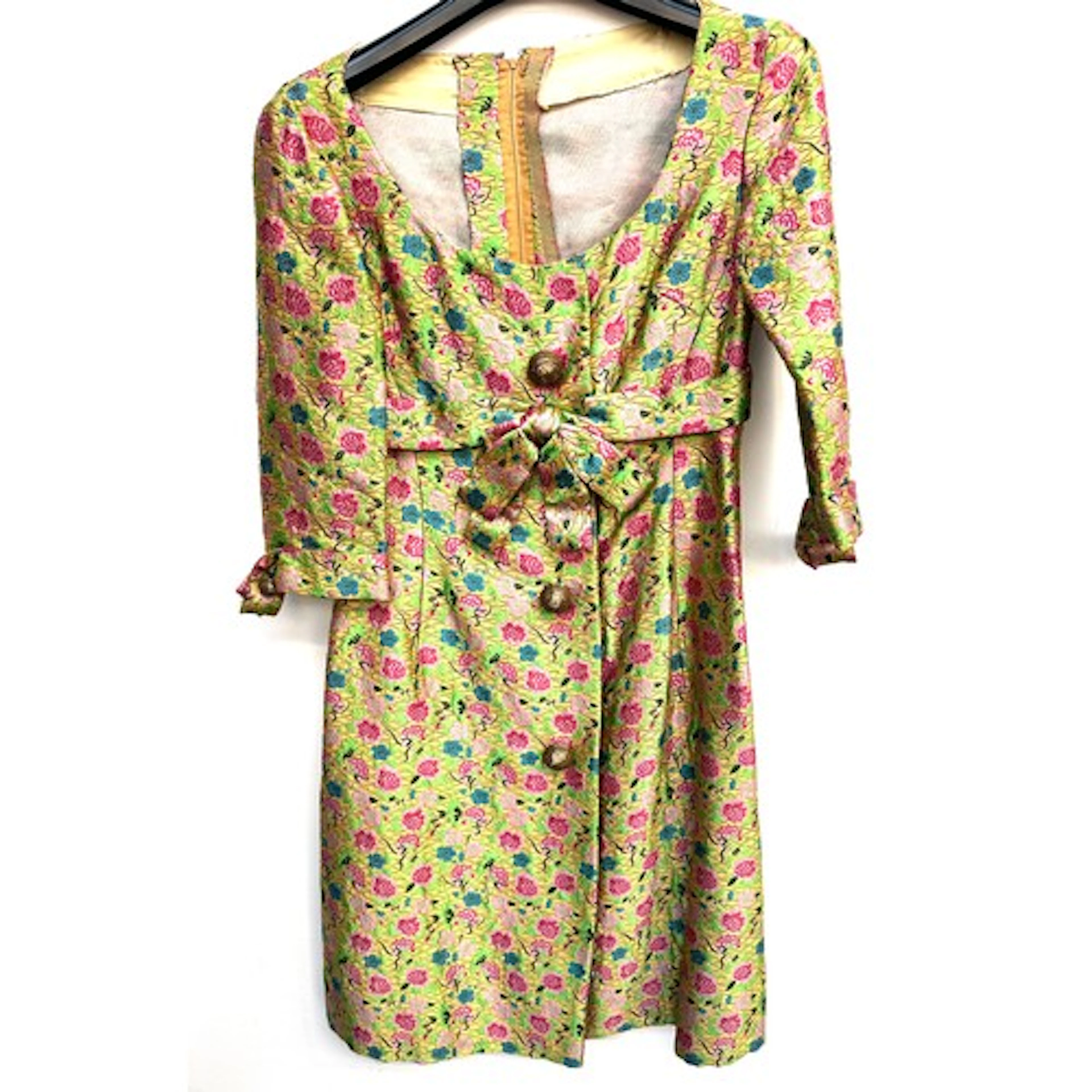 A vintage brocade dress with pink and blue floral pattern on...